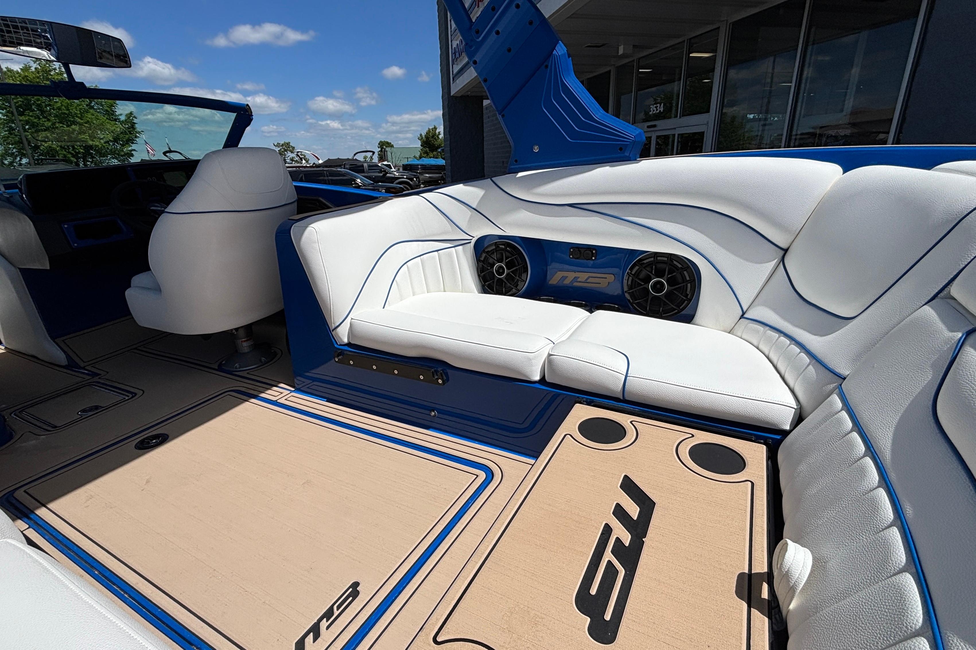 Luxurious interior of 2026 MB B52 23 Alpha boat with white seating and blue accents.