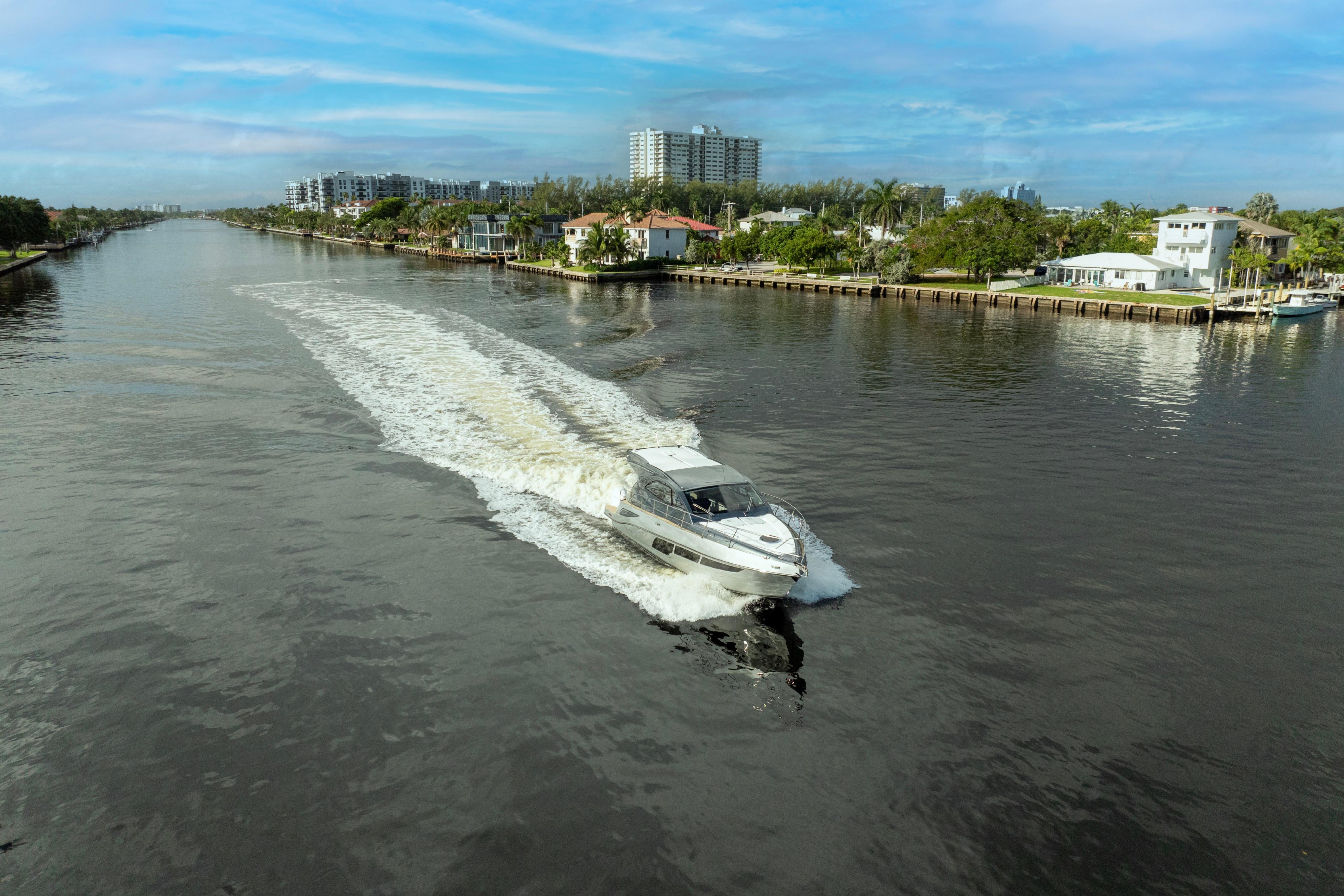 Valiatt 410HT 2025 cruising on a scenic river with waterfront homes.