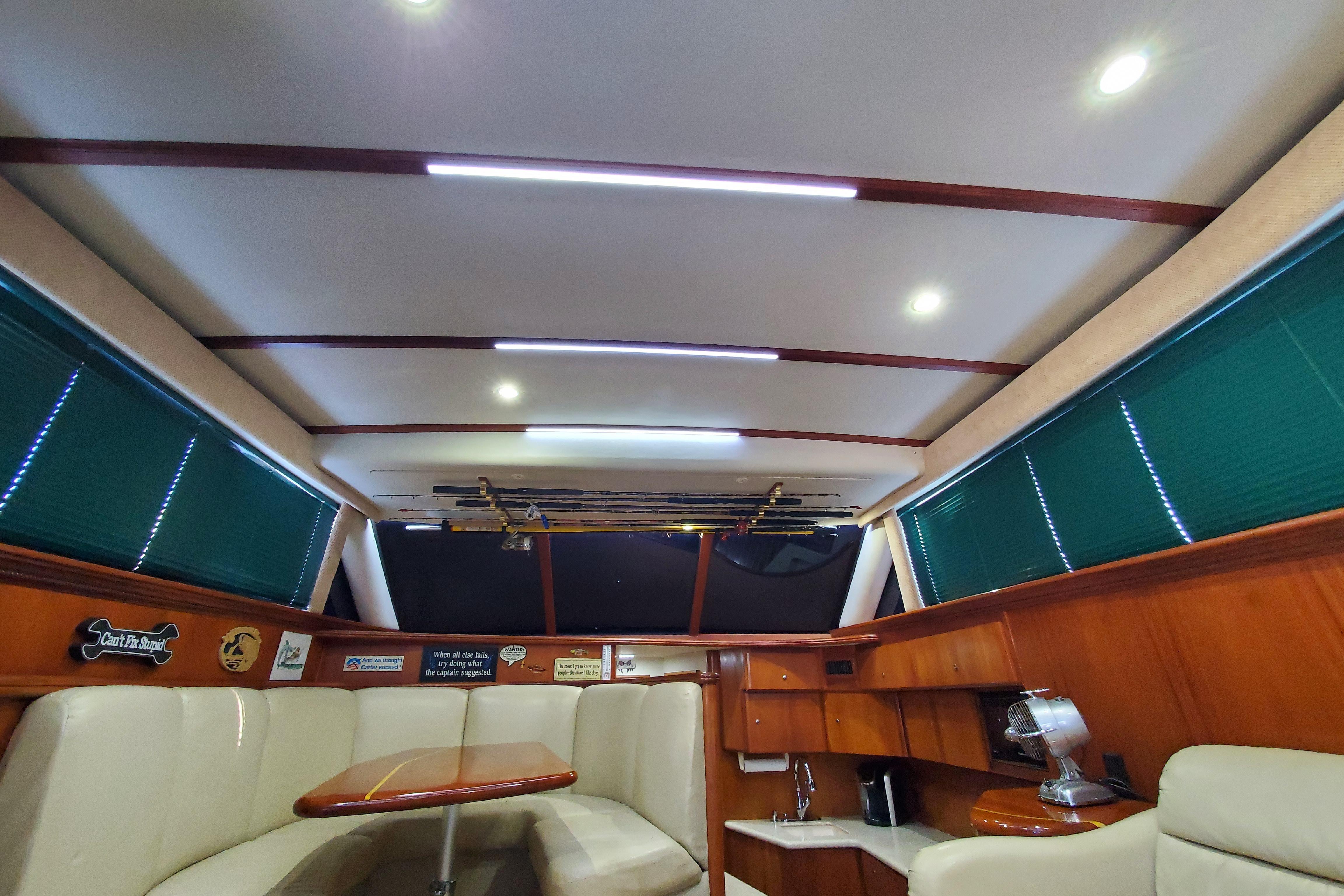 Interior of a 2000 Silverton 42 Convertible yacht with seating and wooden cabinetry.
