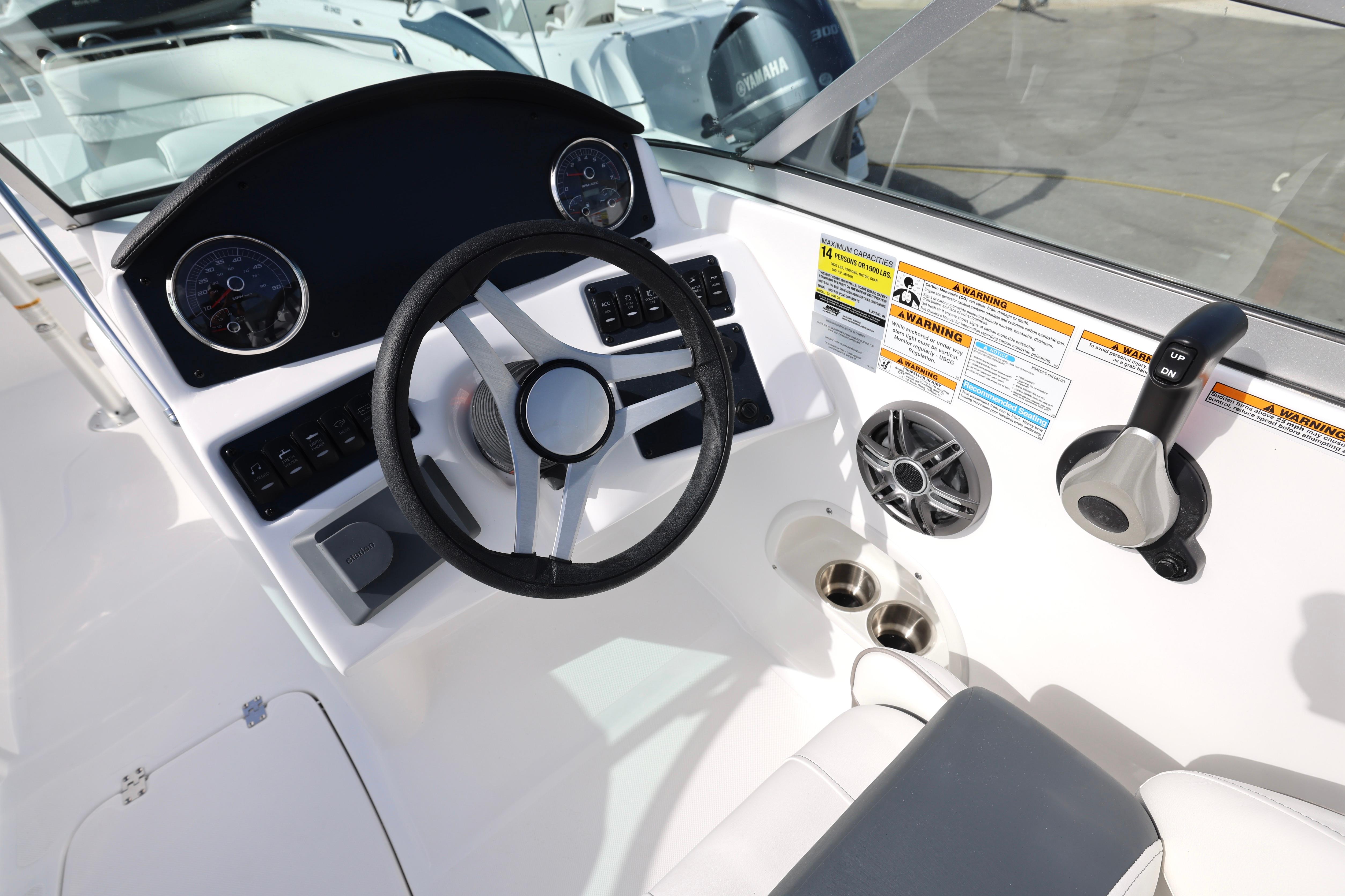 2026 Hurricane SunDeck 2486 OB boat dashboard with steering wheel and control panel.