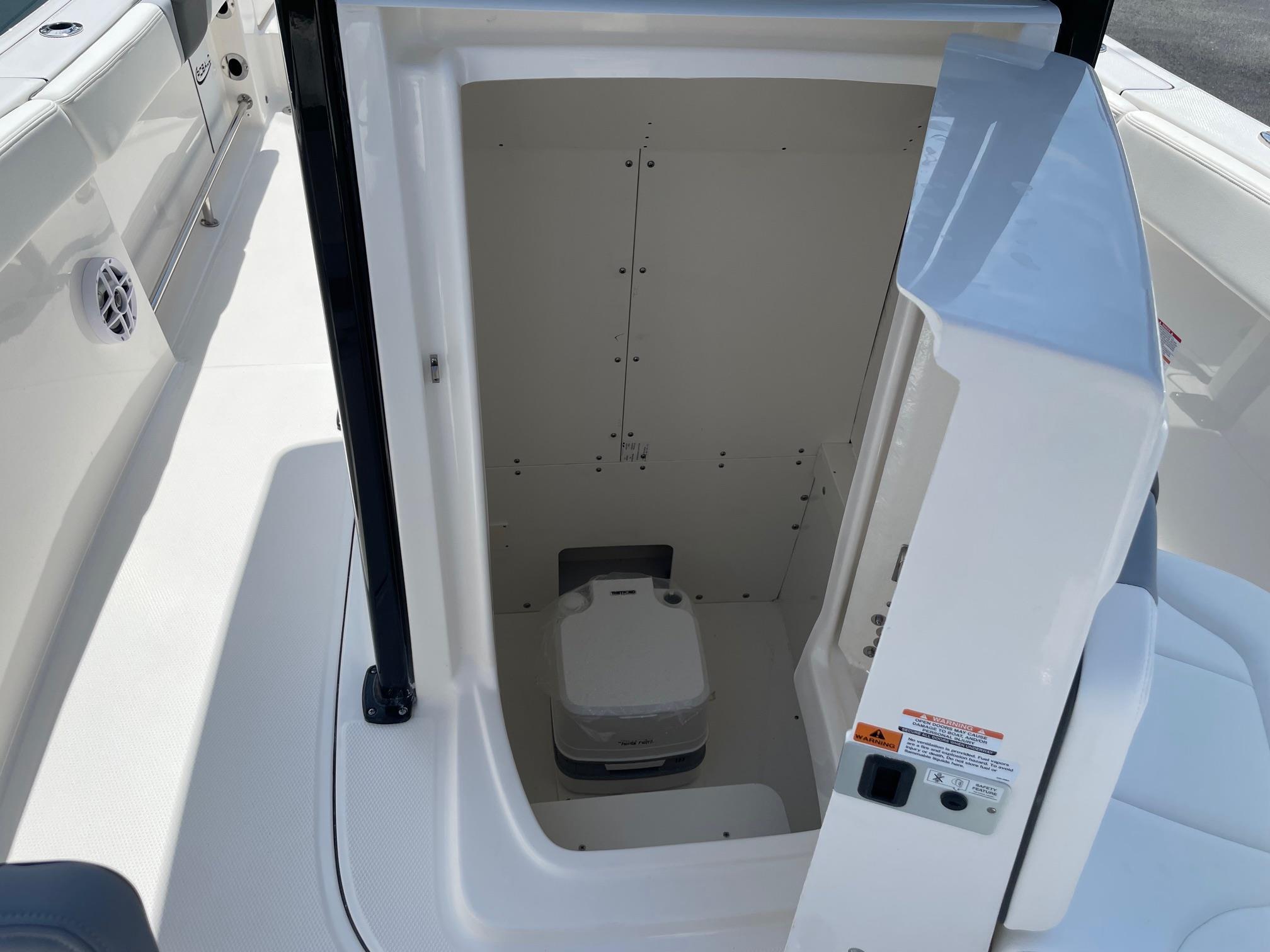 2025 Robalo R230 Center Console boat interior with compact marine toilet.