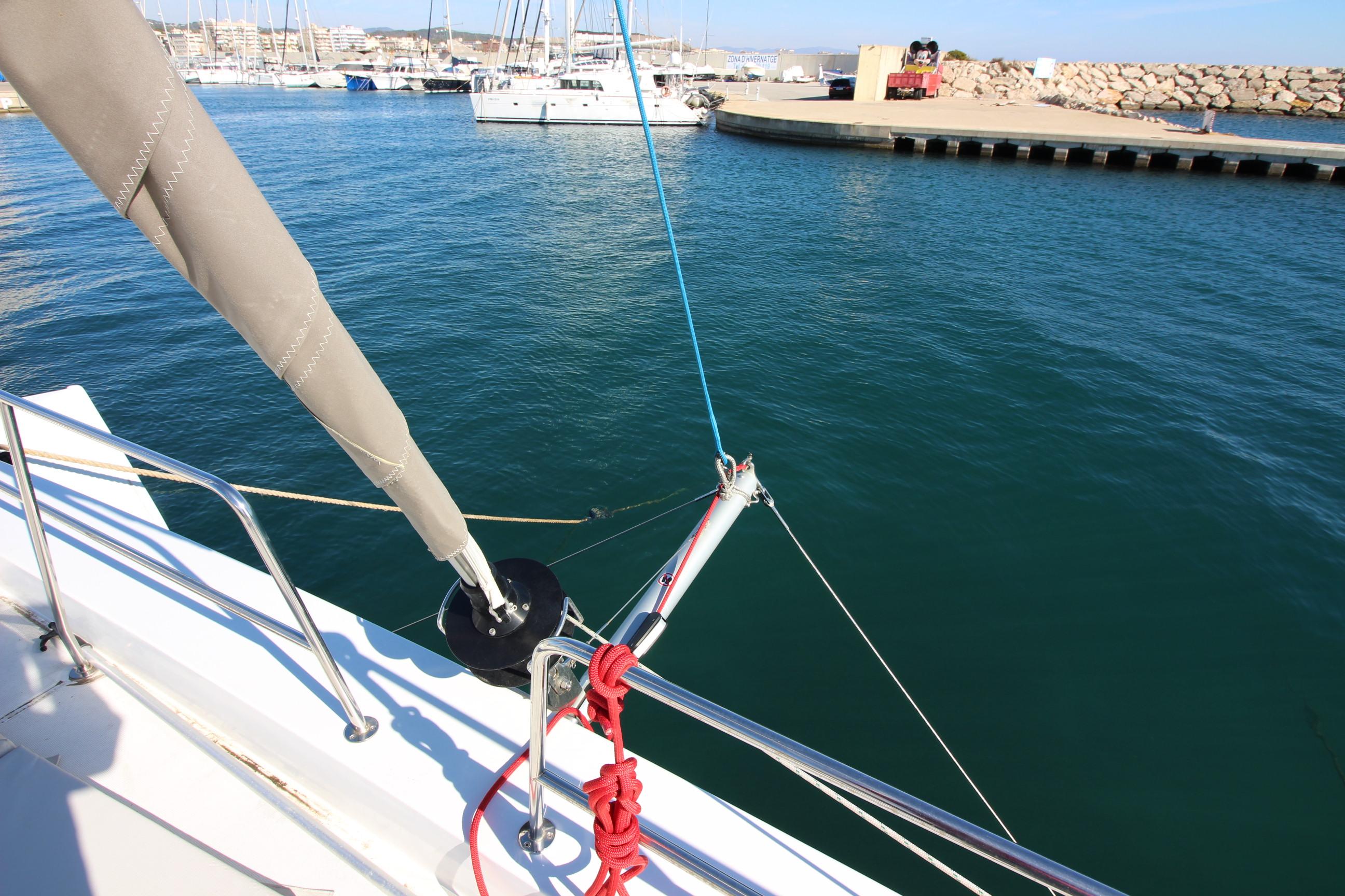 Sailboat deck view, Bali 5.4 model, 2022, docked in a marina with clear blue water.
