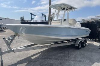 2024 Boston Whaler 220 Dauntless boat on a trailer, parked outdoors.