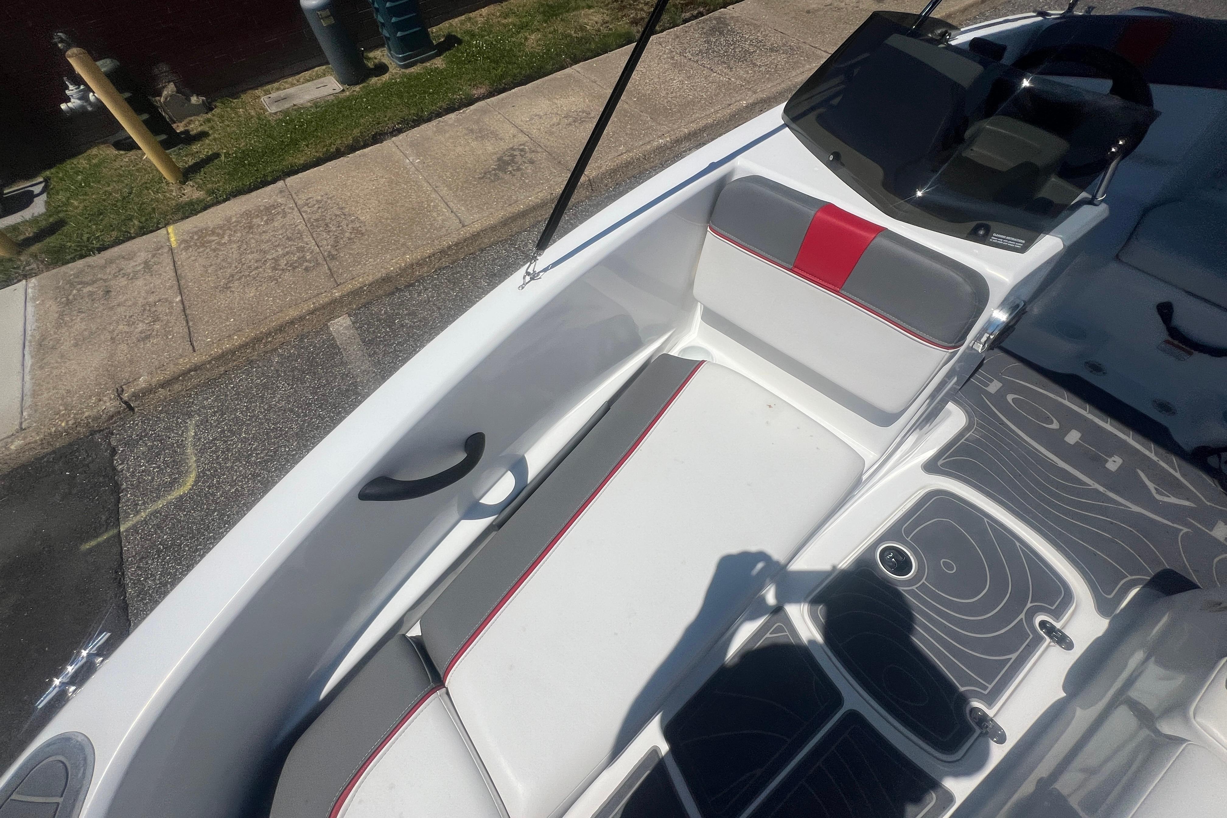 2023 Tahoe T16 boat interior with white and gray seating, red accents, and modern dashboard.