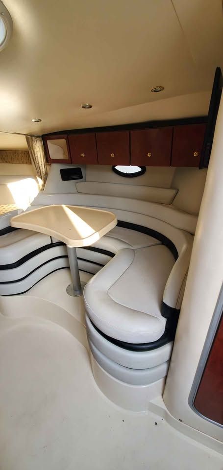 Interior of the 2002 Wellcraft 3300 Martinique with curved seating area and table.