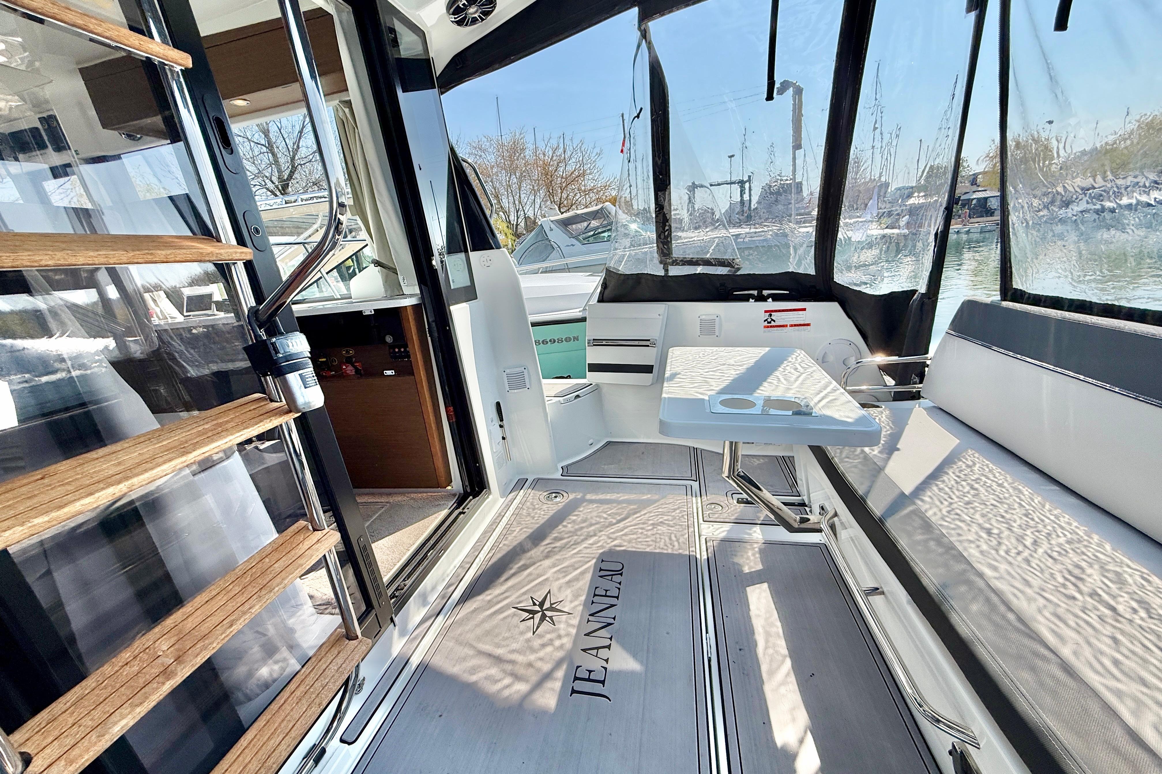 Interior view of 2022 Jeanneau NC 1095 Fly boat, featuring seating and table.