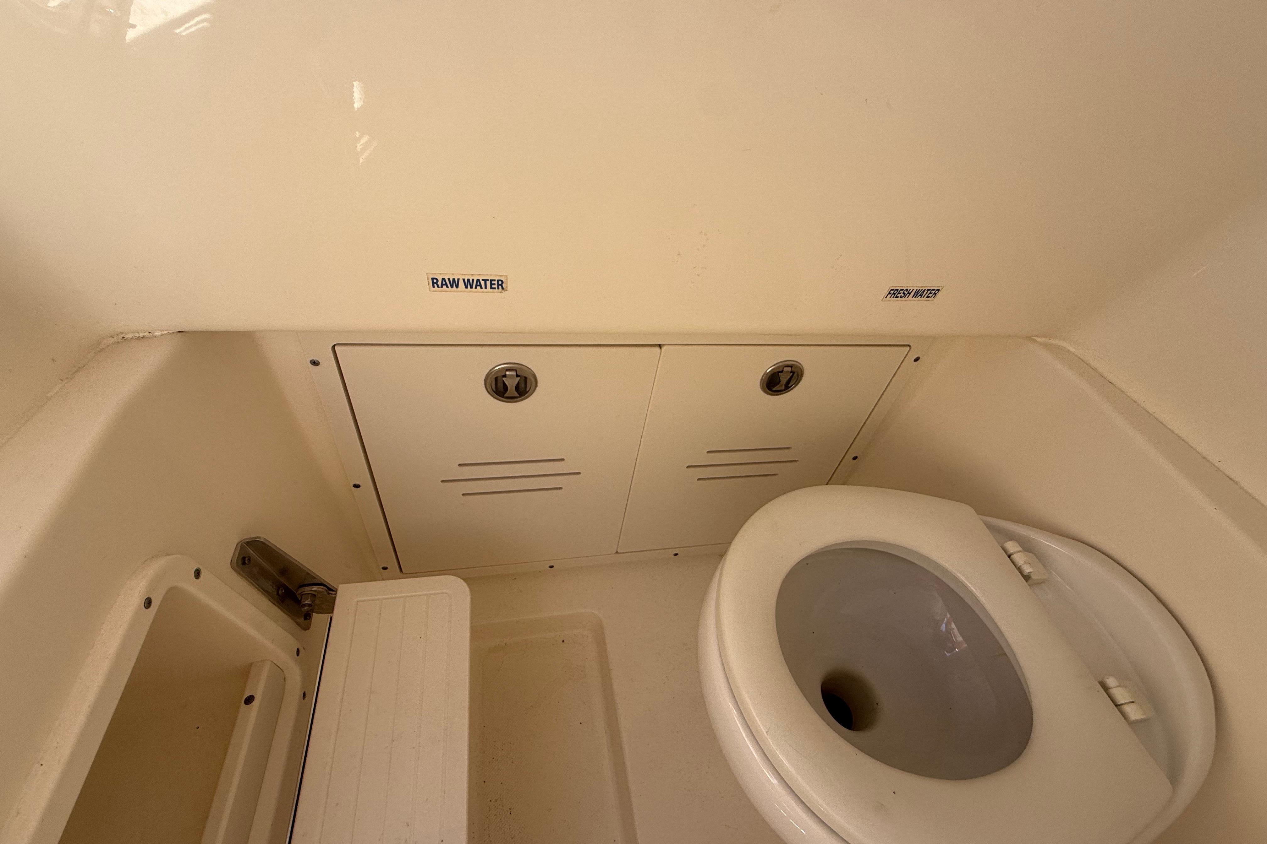 2019 Key West Billistic 281 Center Console boat bathroom interior with toilet and storage compartments.