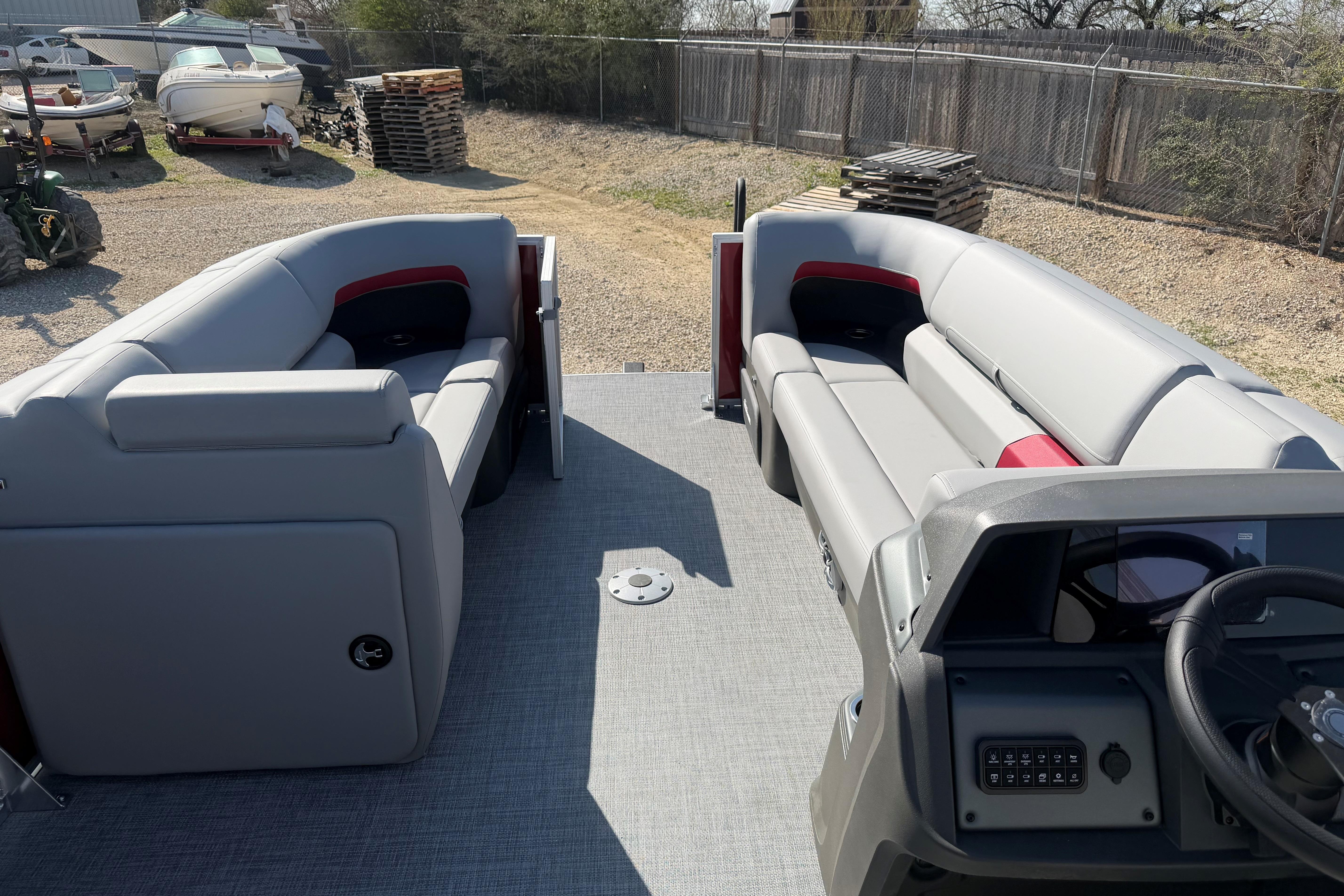 2026 Sun Tracker Party Barge 22 DLX interior with gray seating and steering console.