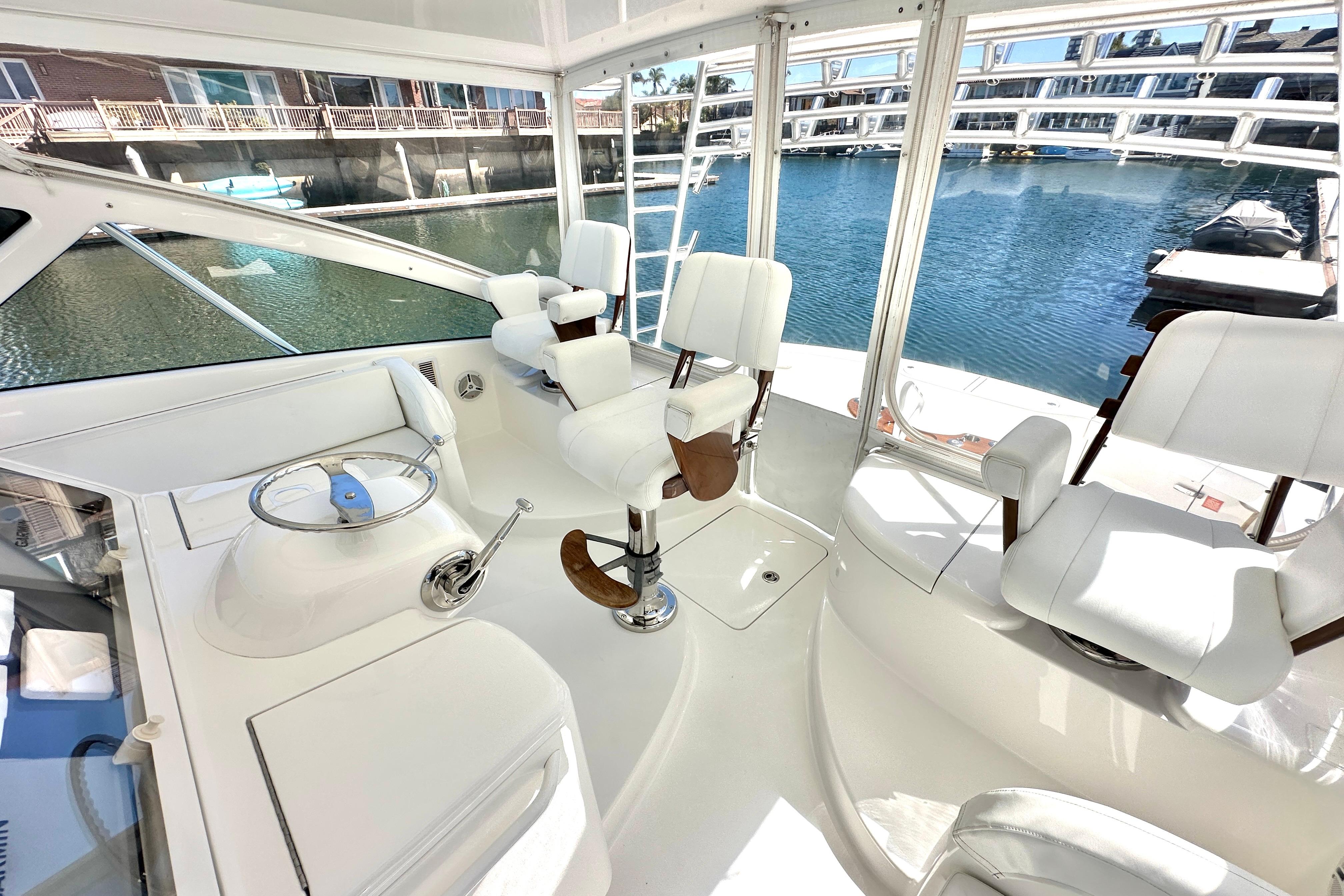 Interior view of 2012 Viking 42 Open yacht with white seating and helm.