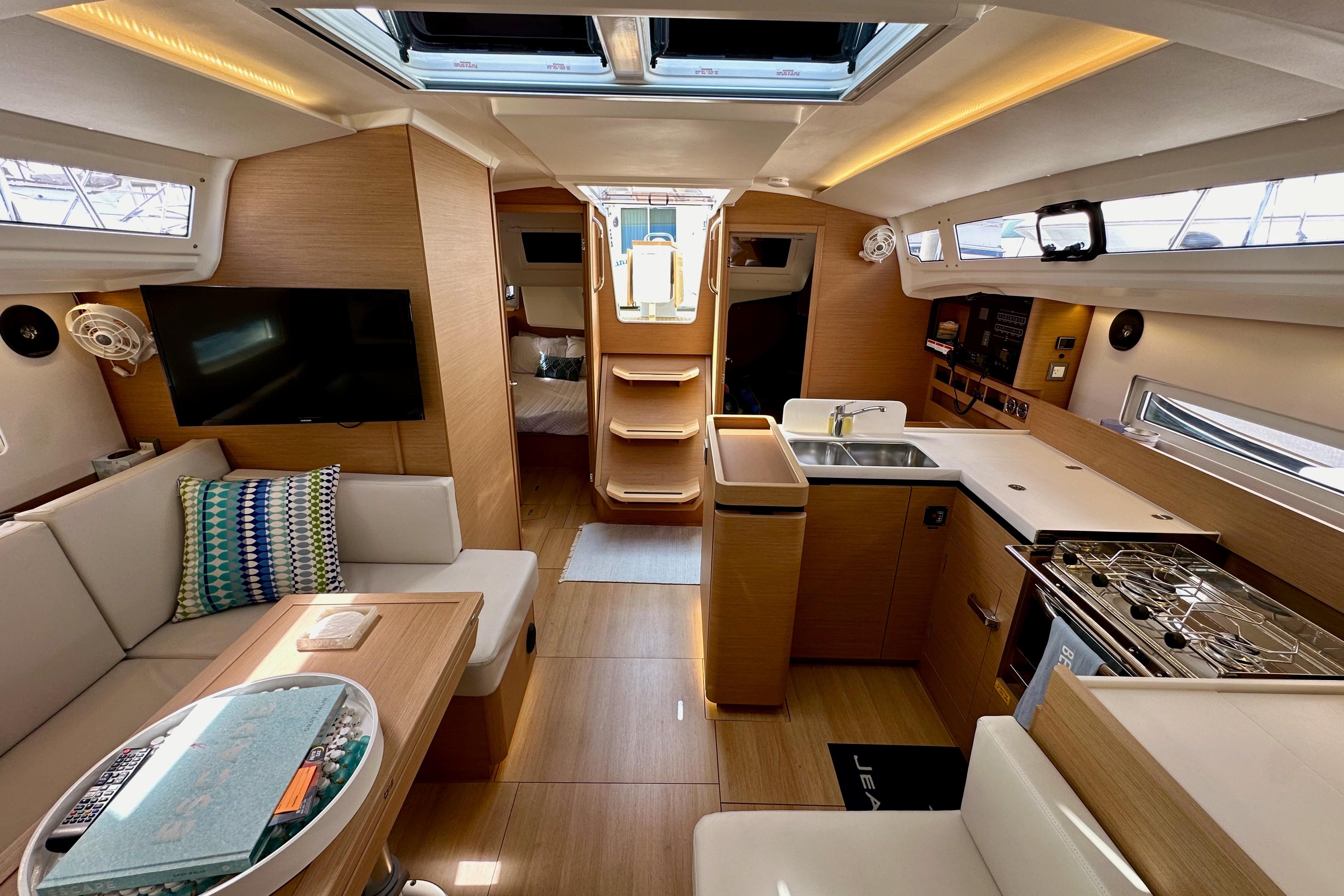 Luxurious interior of 2024 Jeanneau Sun Odyssey 410 sailboat, featuring modern kitchen and seating area.