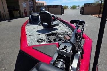 2025 Tracker Pro Team 175 boat with red exterior, parked outdoors.