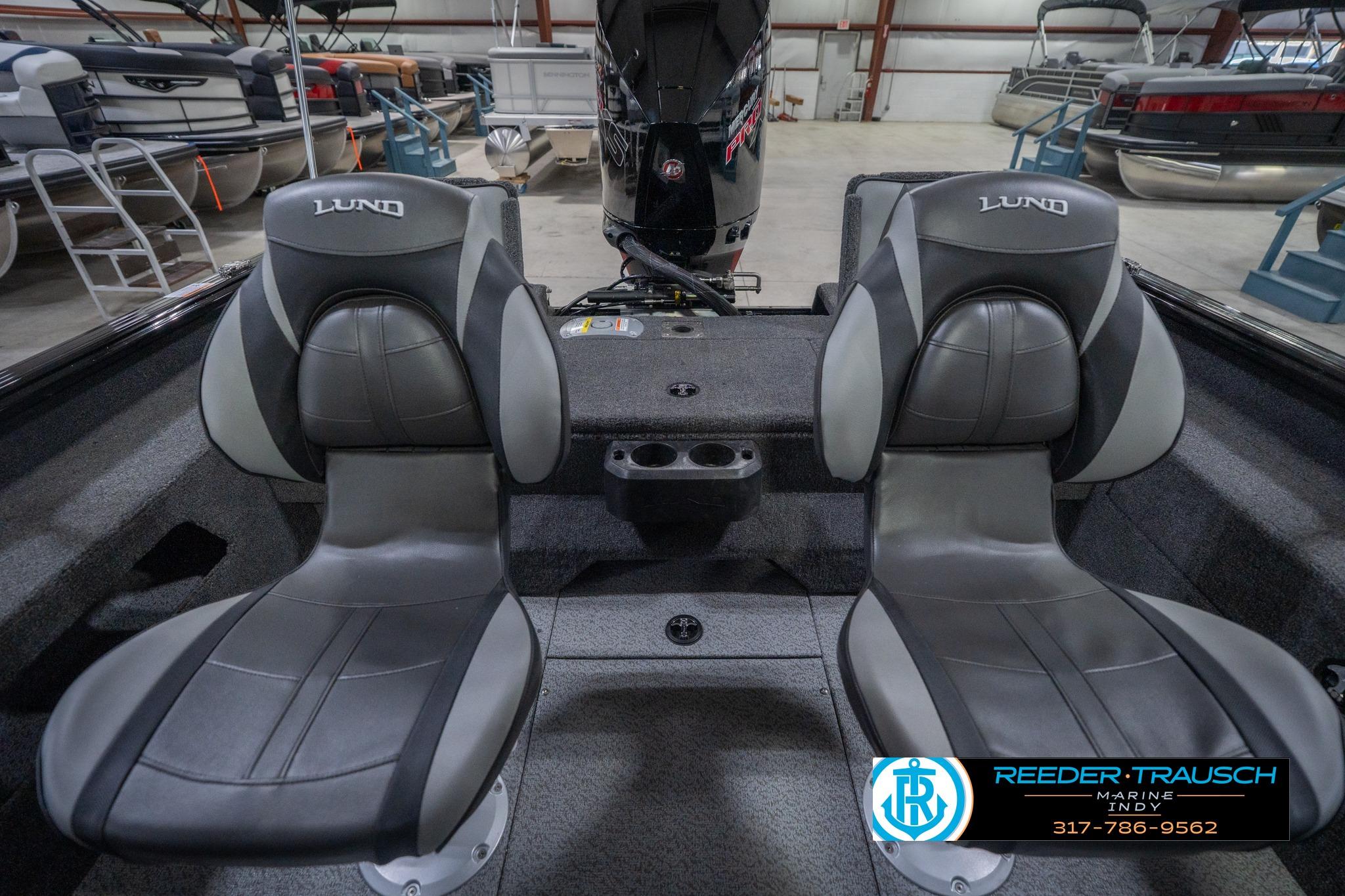 2026 Lund 2075 Impact XS boat interior with two gray seats in a showroom.