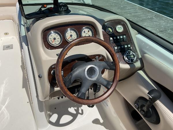 2006 Chaparral 256 SSi boat dashboard with wood-trimmed steering wheel and gauges.