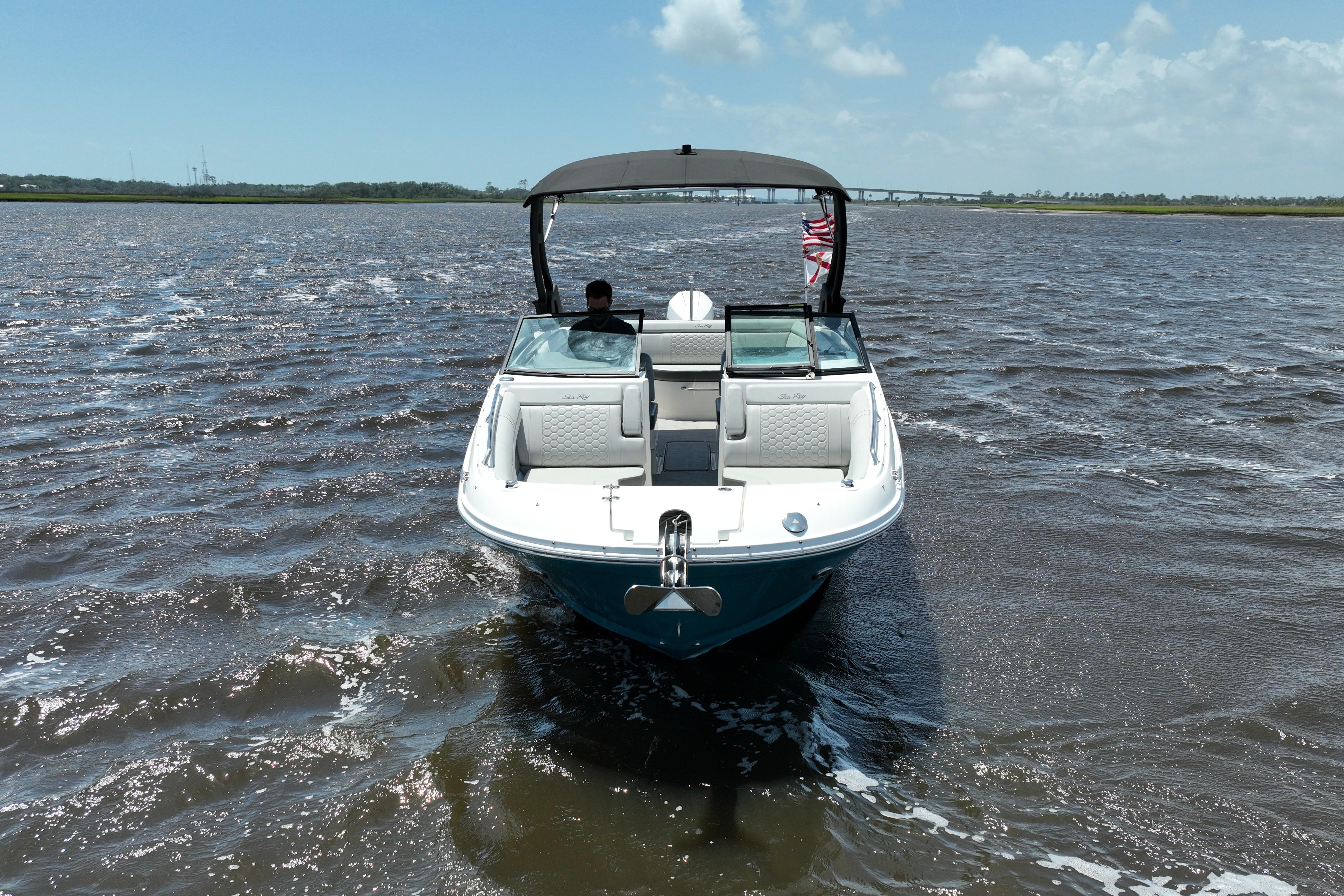 2024 Sea Ray SDX 270 Outboard boat cruising on open water under a clear sky.