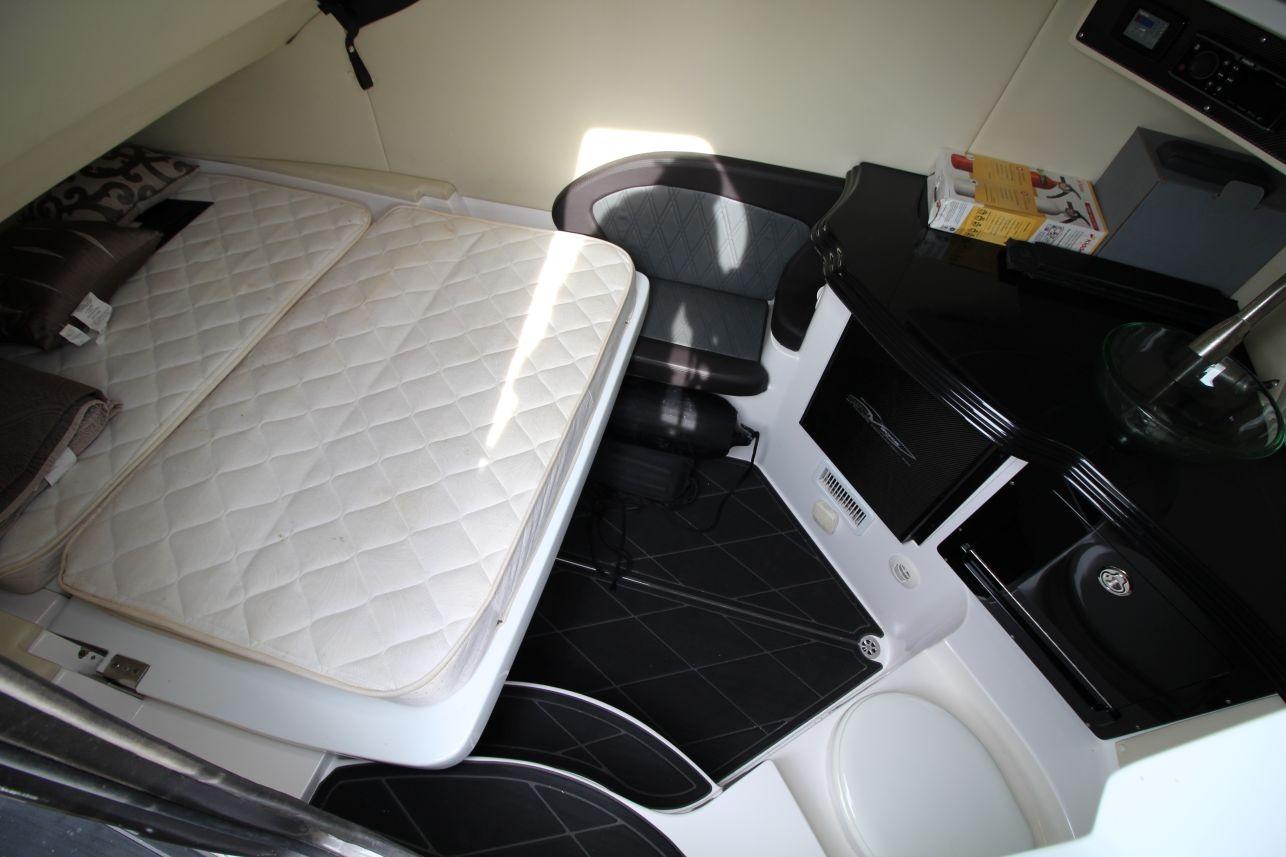 2018 MTI V42 cabin interior with bed, seating, and compact kitchenette.