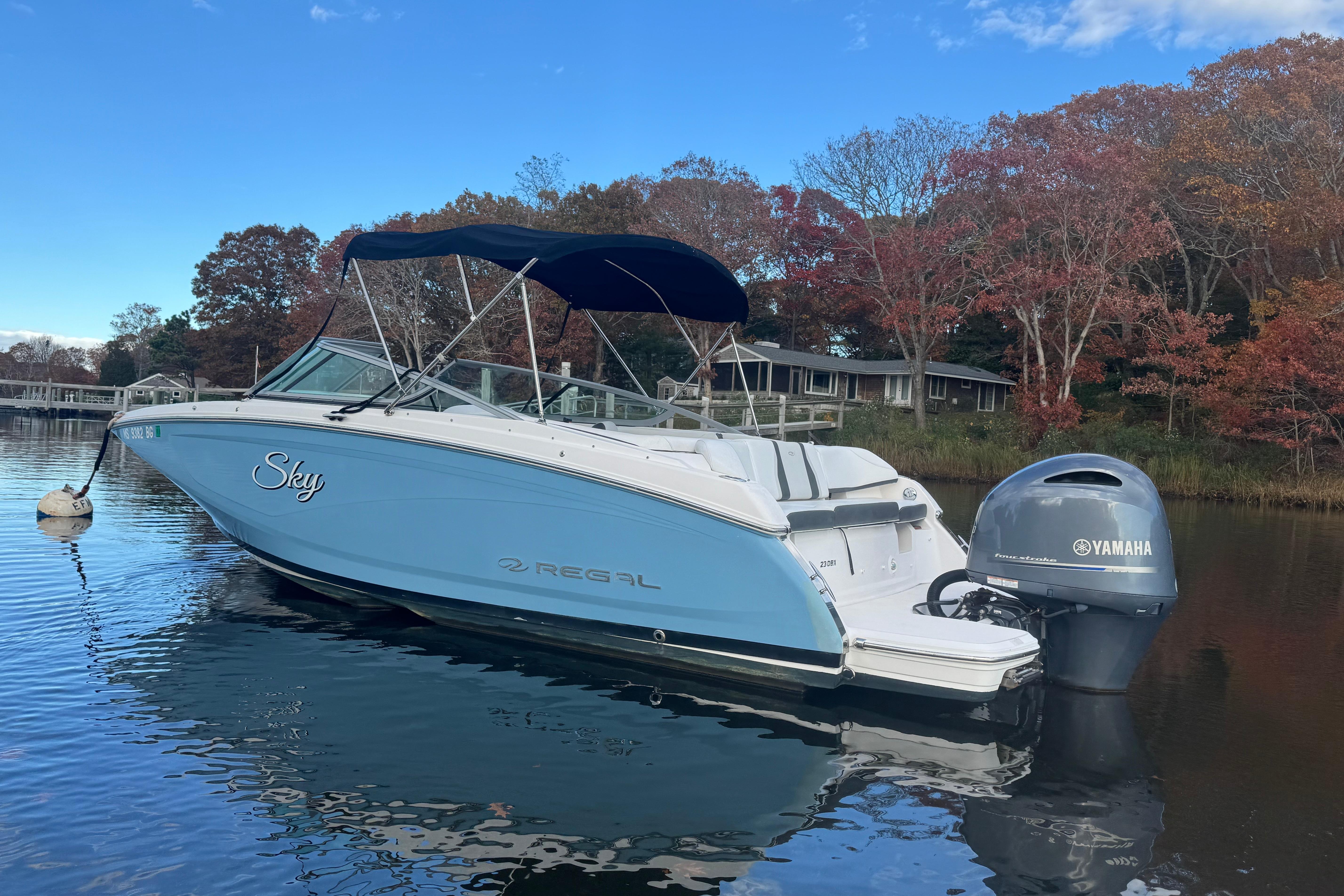 2017 Regal 23 OBX boat with Yamaha engine on calm water, surrounded by autumn trees.