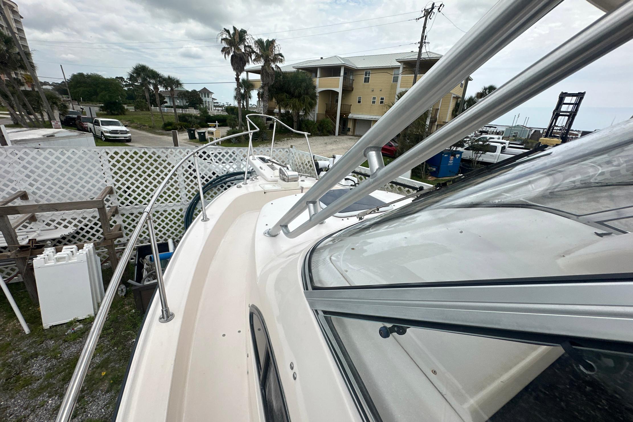 2006 Grady-White Marlin 300 boat docked near coastal homes and palm trees.