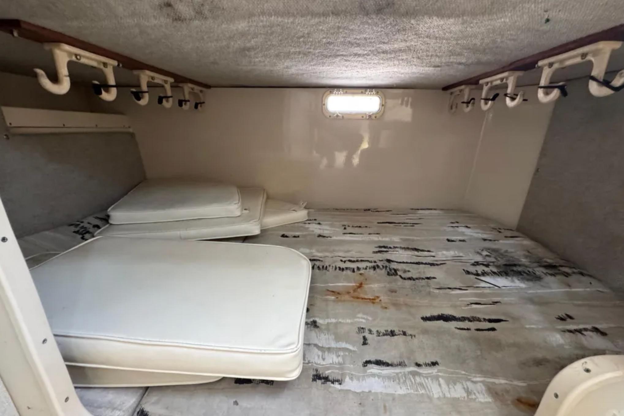 Interior cabin of 1990 Grady-White Marlin 280 boat with cushions and rod holders.