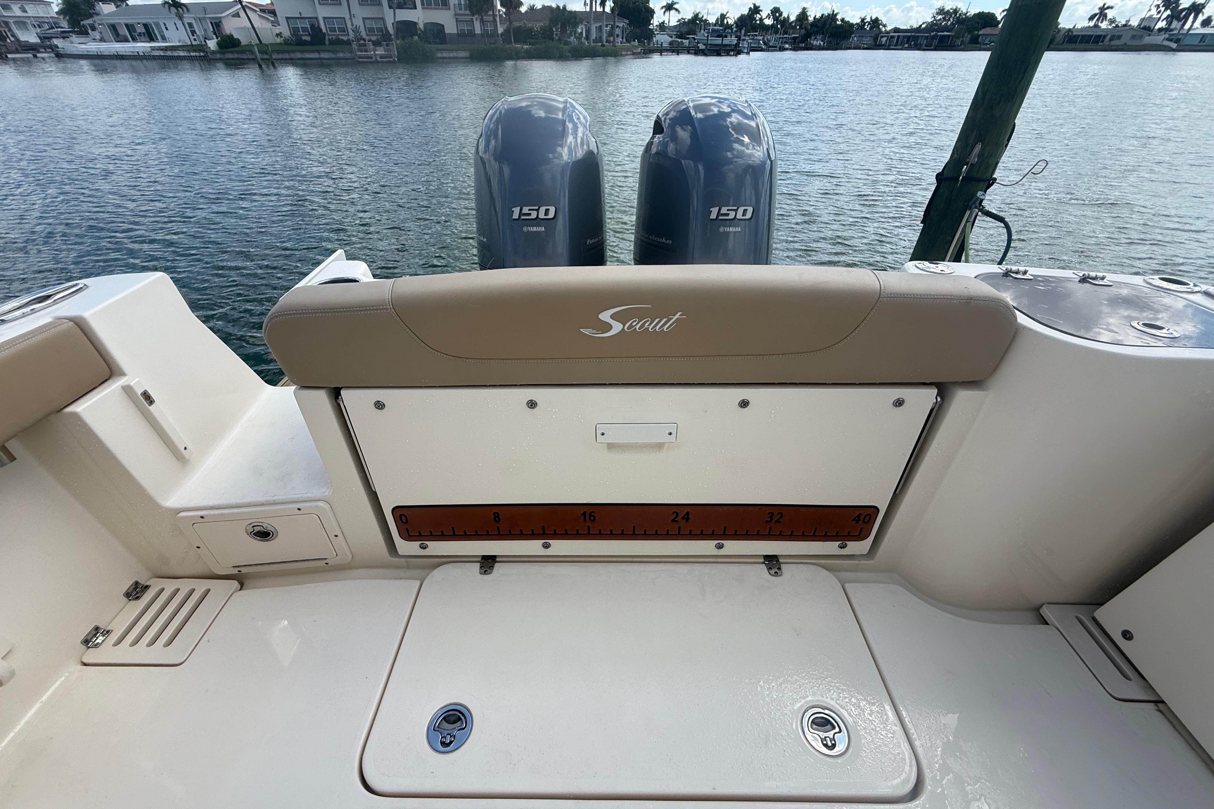 2023 Scout 255 Dorado boat with dual Yamaha 150 engines on a calm waterfront.