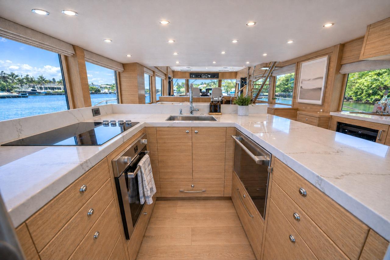 Luxurious kitchen interior of 2027 Offshore Yachts 70 CE with modern appliances and scenic views.