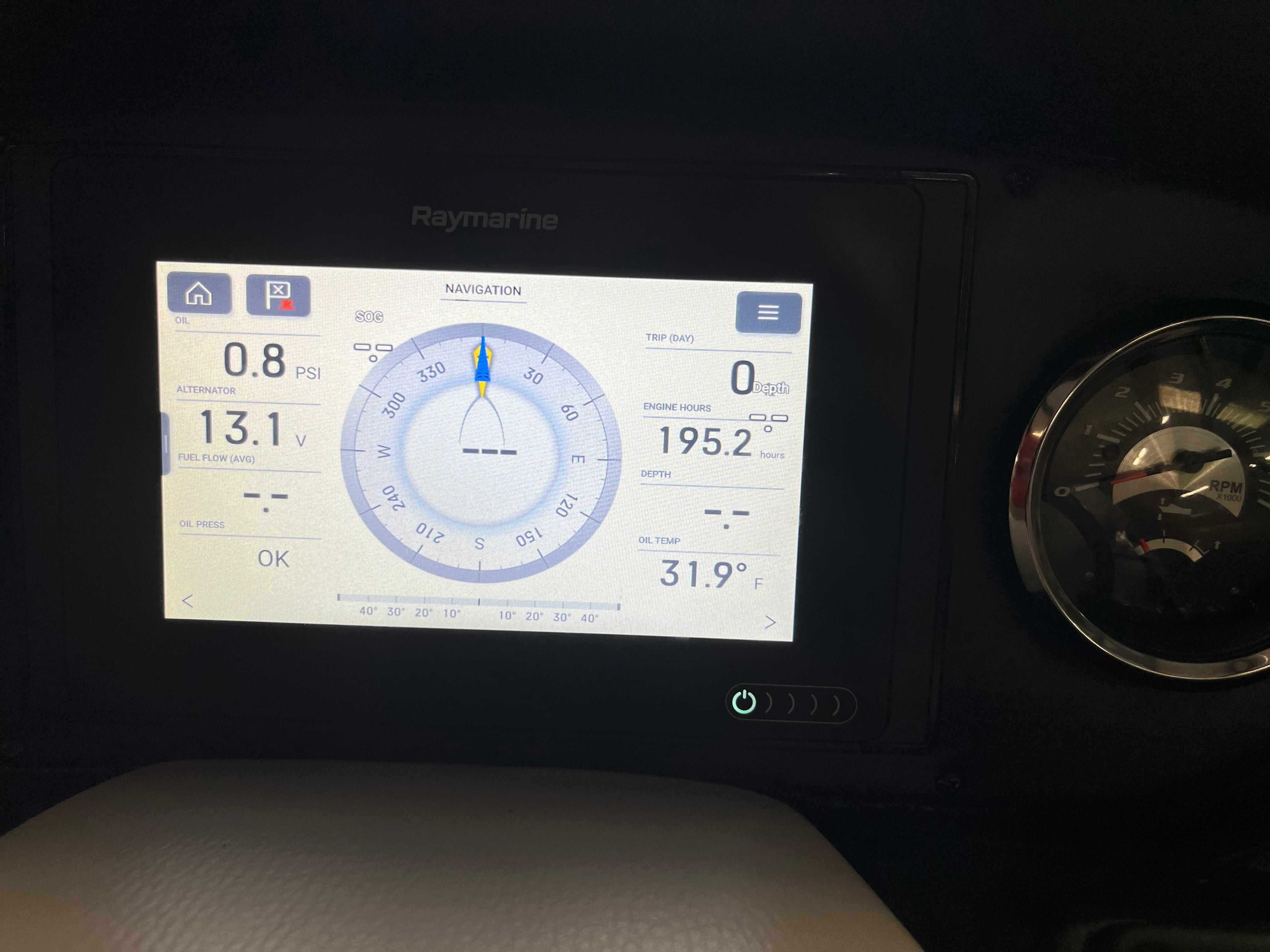 A navigation display shows speed, heading, and temperature. An analog gauge is visible beside it.