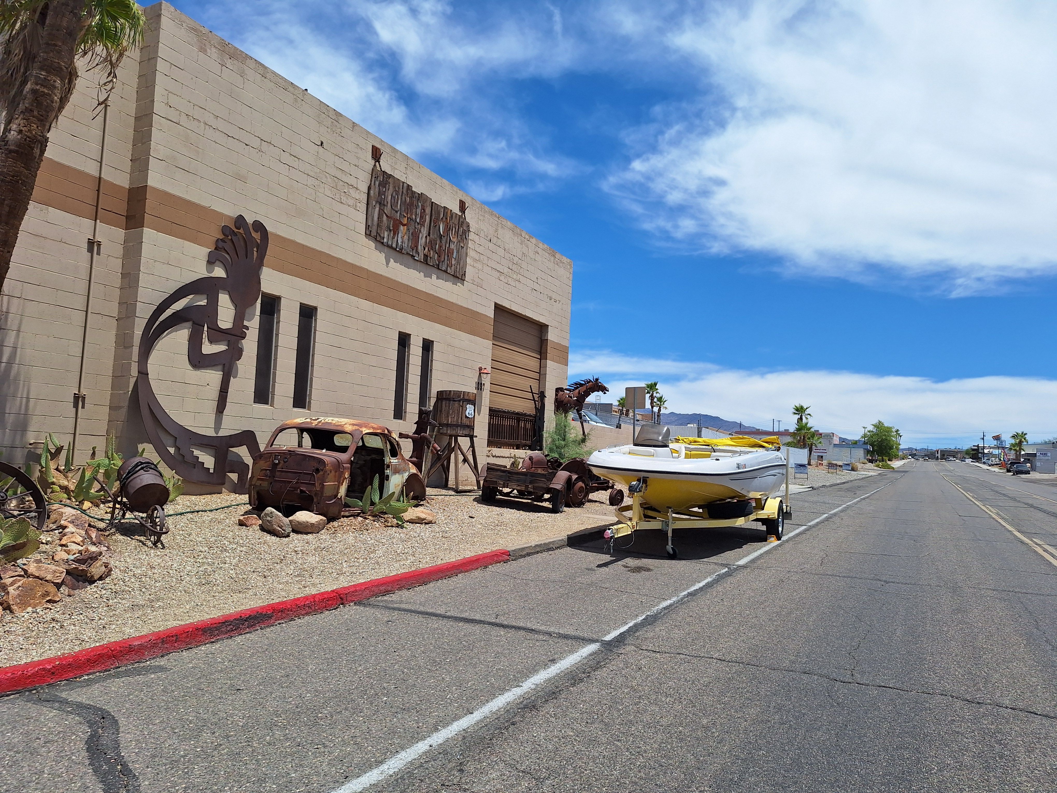 2004 Tracker Tahoe boat in front of desert art and vintage cars.