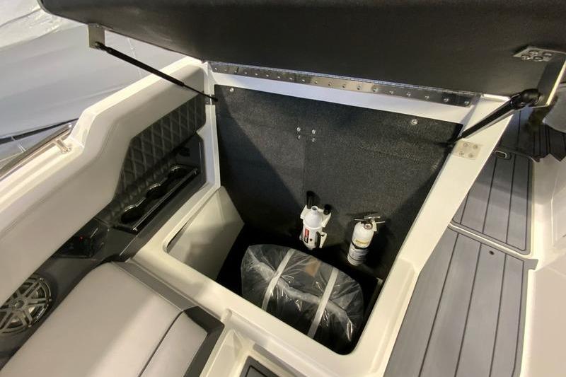 2026 Cobalt R31 boat storage compartment with fire extinguishers and wrapped equipment.