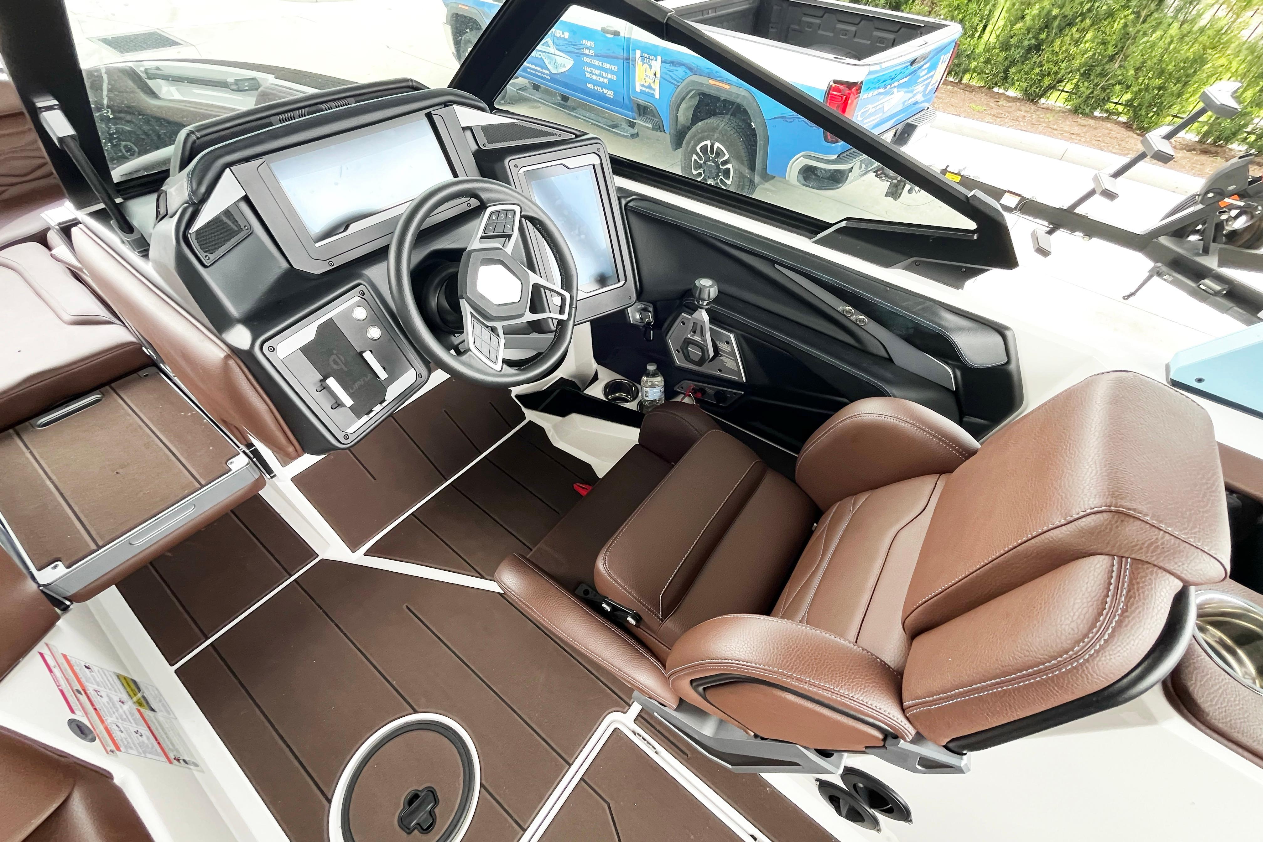 2025 Supra SA450 boat interior with brown leather seats and modern dashboard controls.