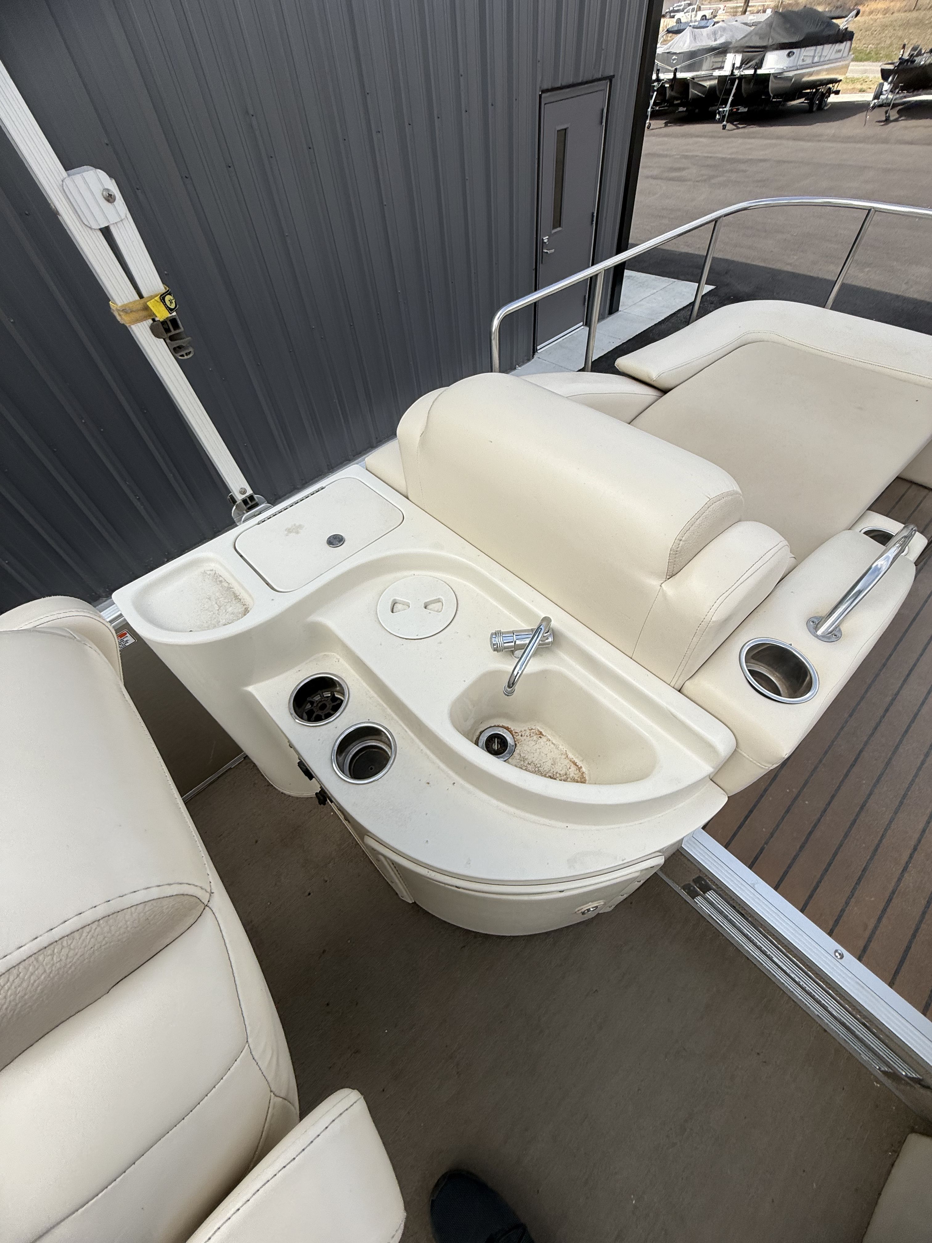 Interior of 2014 Bennington 2575RCW-I/O with seating and sink area.