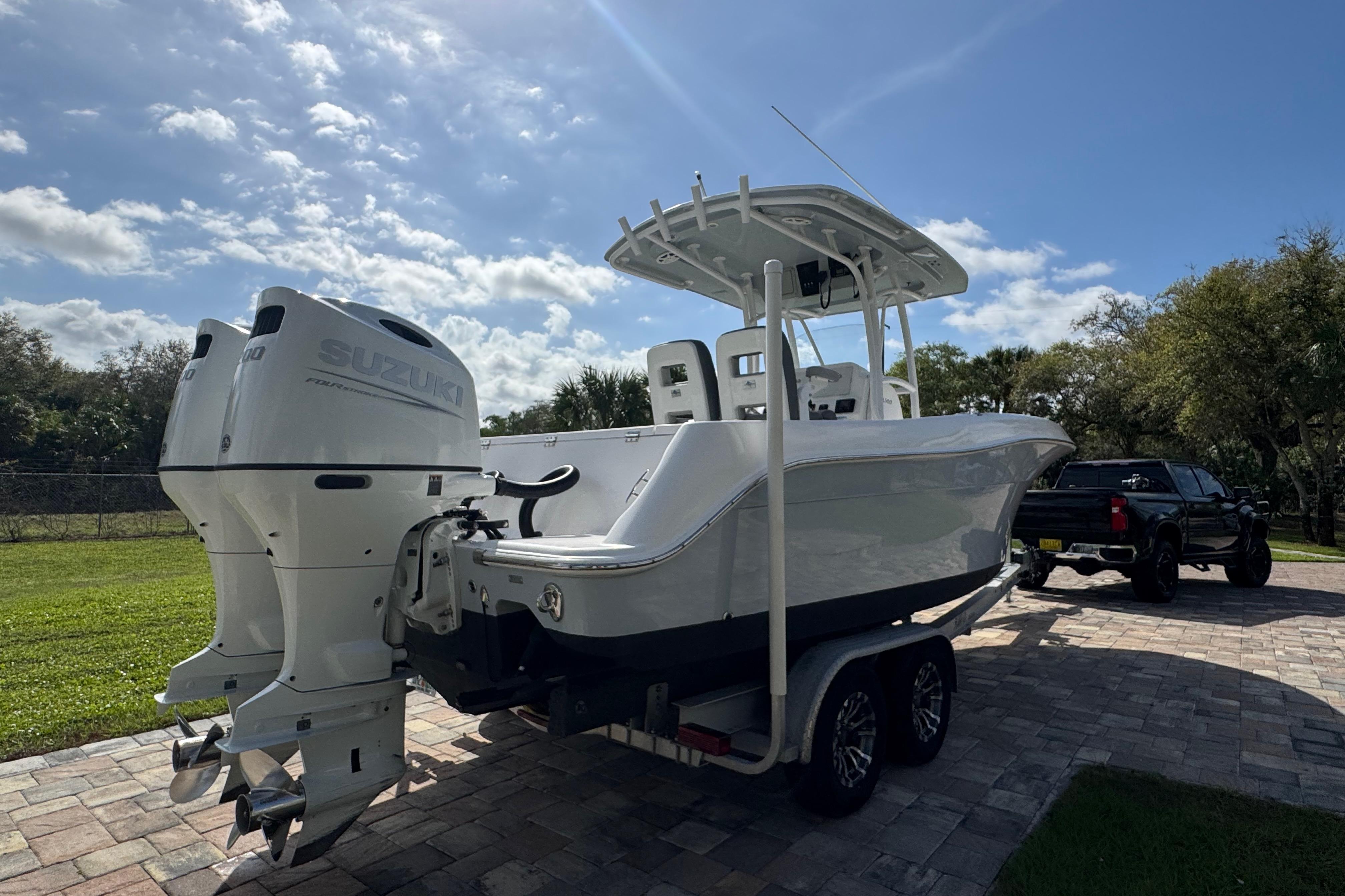 2022 Aquasport 2500 Center Console boat with dual Suzuki engines on a trailer.