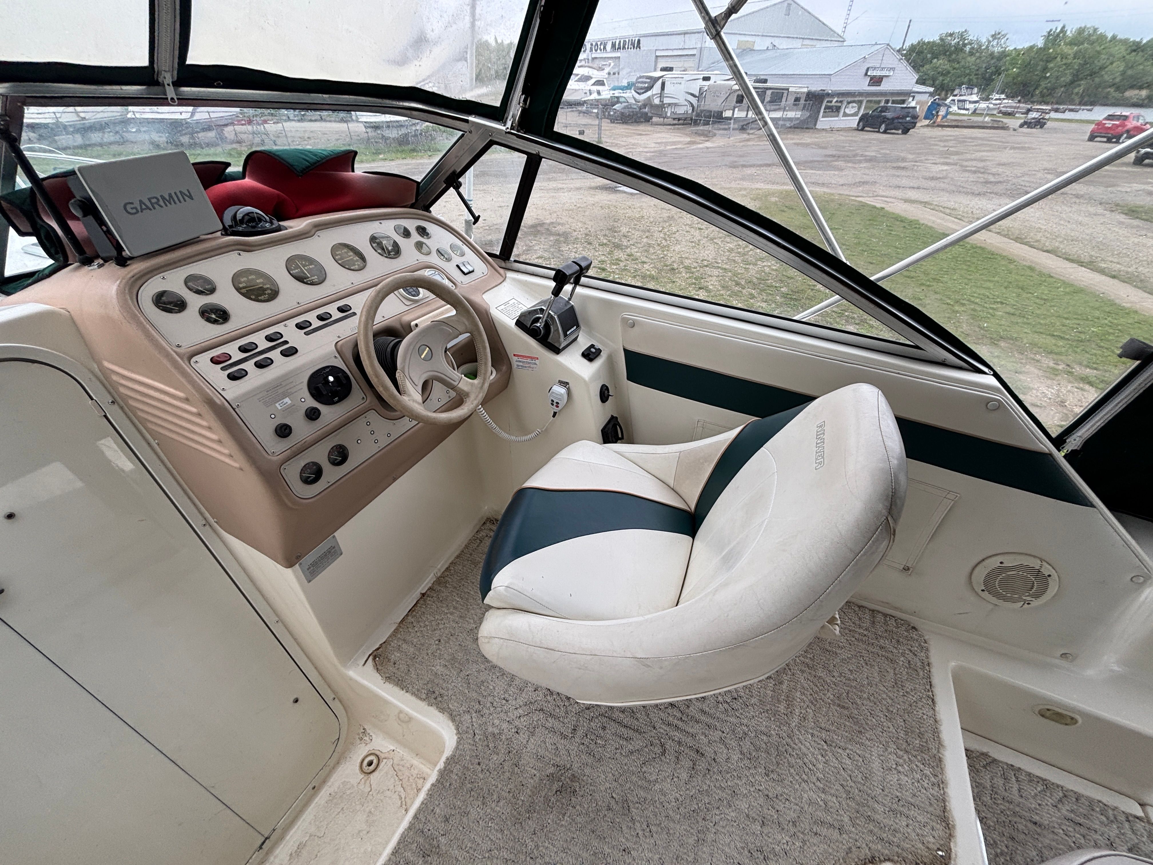 The cockpit of a Rinker Fiesta Vee 280 with steering wheel, instruments, and a seat.