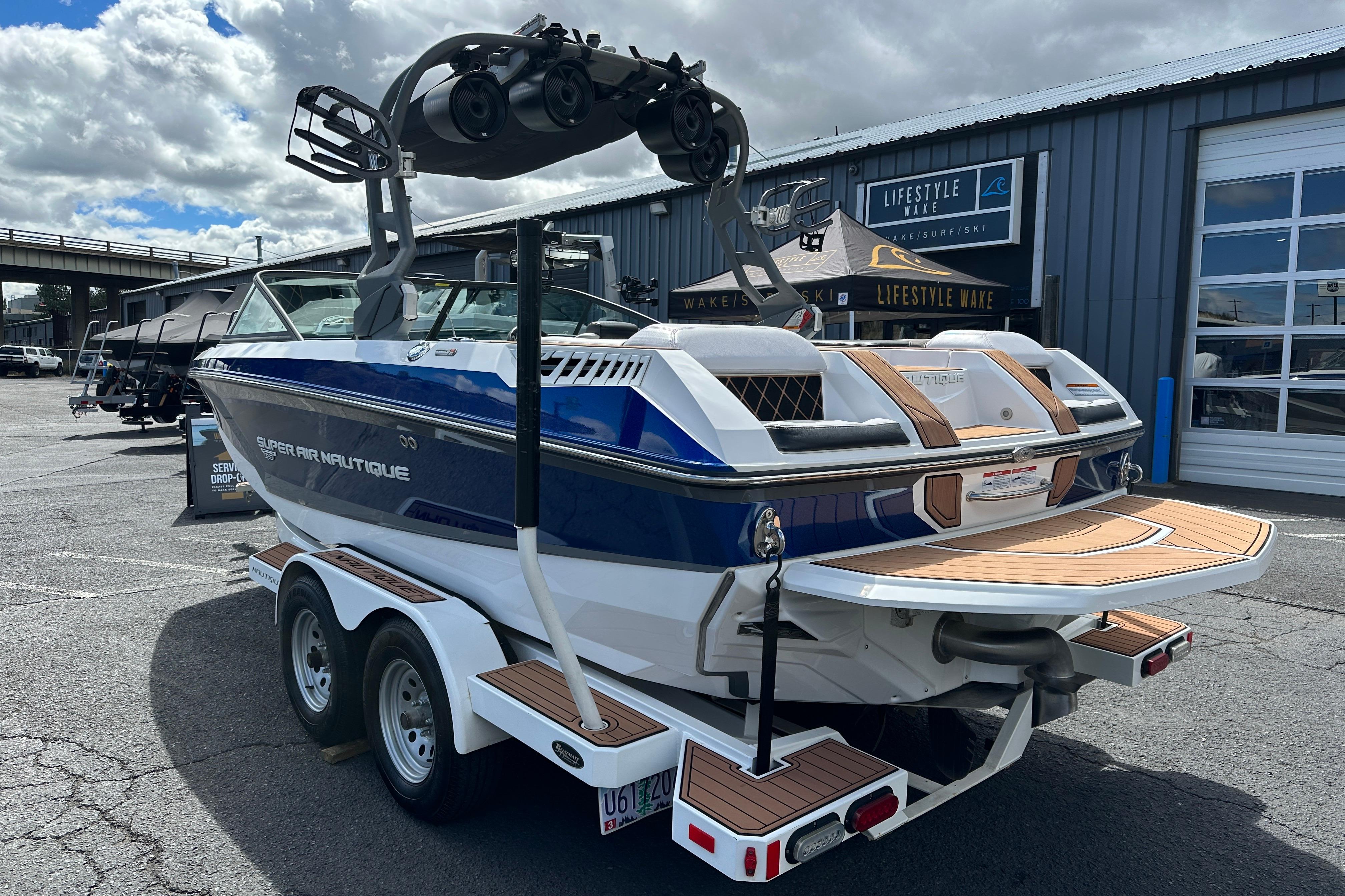 2017 Nautique Super Air Nautique GS20 boat on trailer, parked outside a dealership.