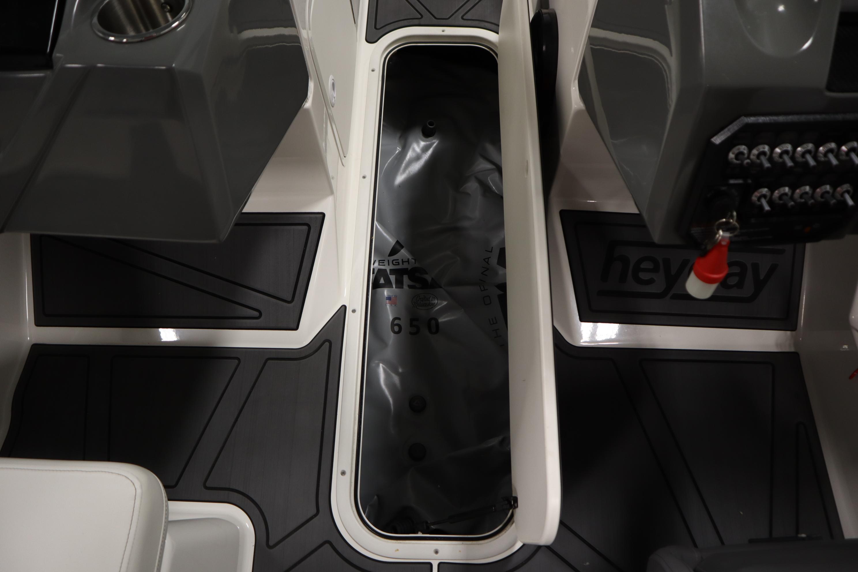 2023 Heyday WT Surf boat interior with storage compartment and control panel.