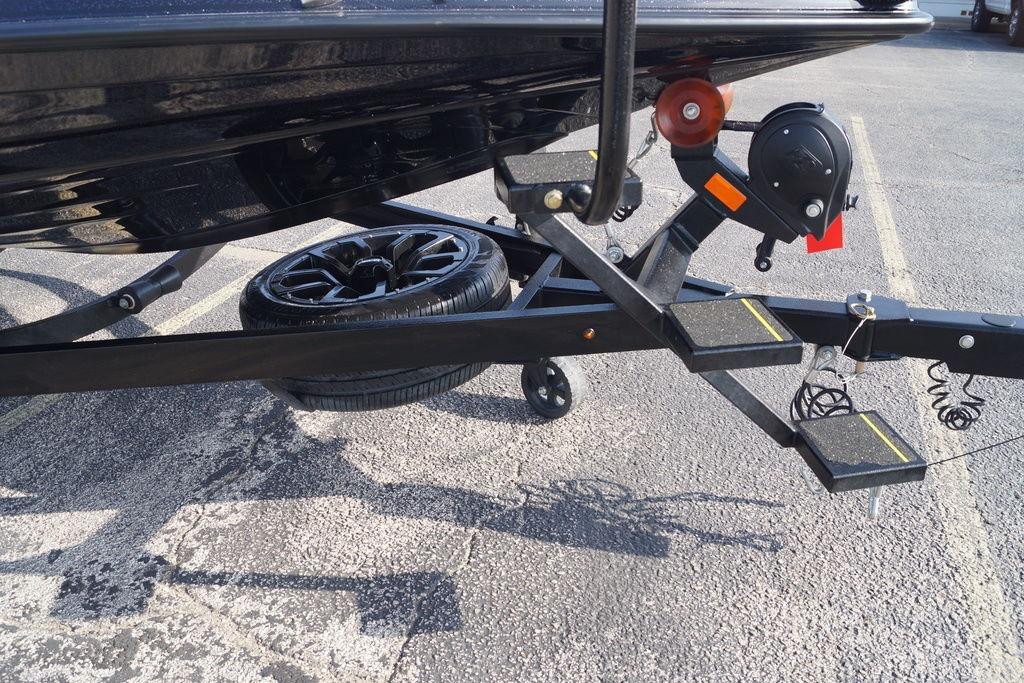 Trailer hitch and spare tire of 2025 Phoenix 921 Elite boat on pavement.