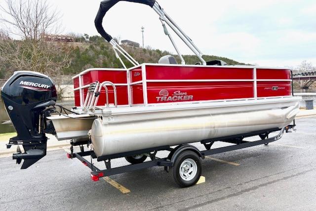 2026 Sun Tracker Party Barge 18 DLX pontoon boat on trailer, featuring a Mercury outboard motor.