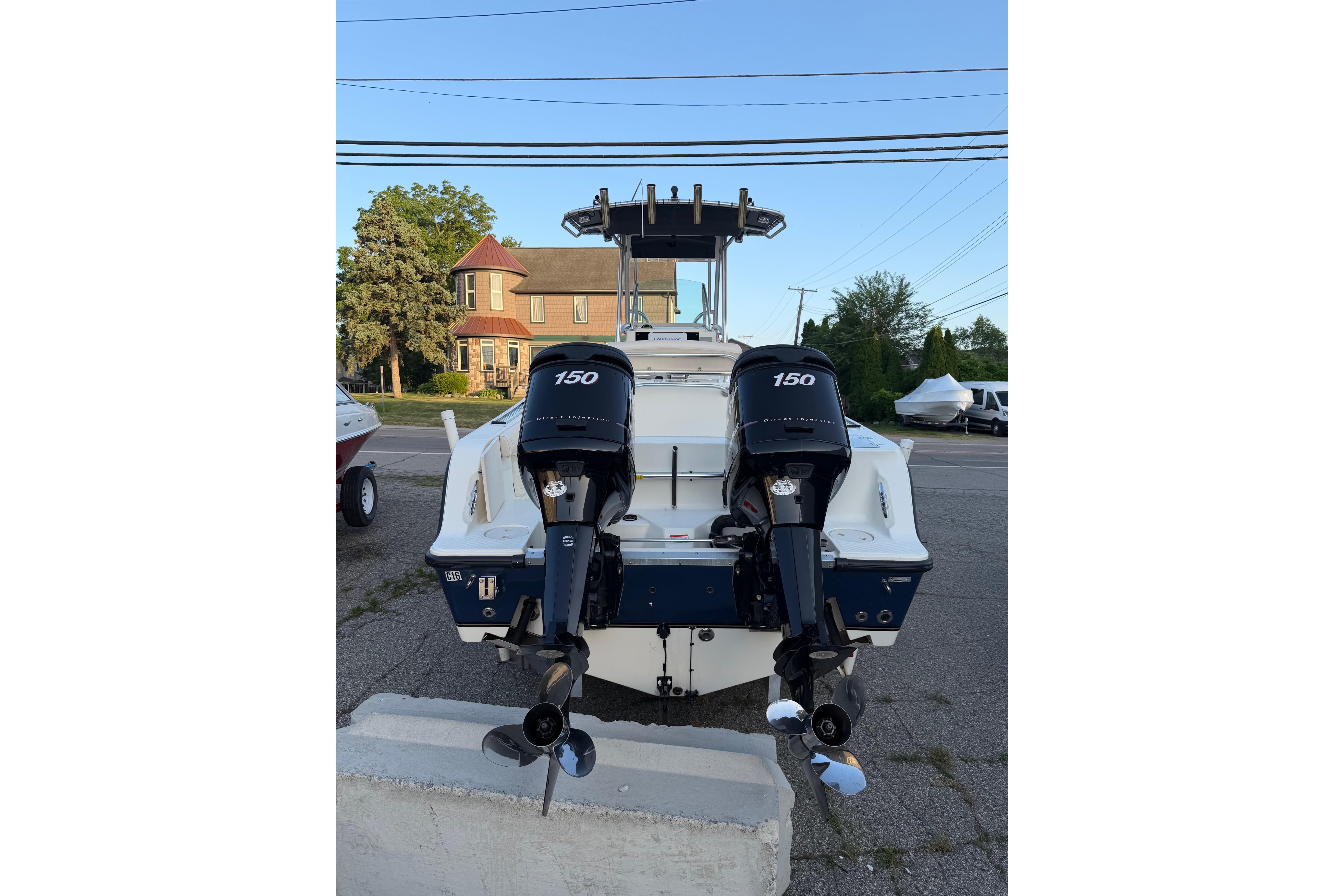 2007 Mako 234 Center Console boat with dual 150 horsepower engines, parked outdoors.