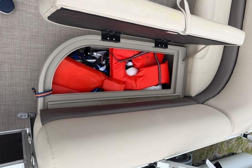 2025 Sun Tracker Party Barge 16 DLX storage compartment with life jackets.