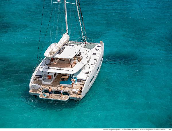 2025 Lagoon 55 yacht on turquoise water, featuring spacious deck and modern design.