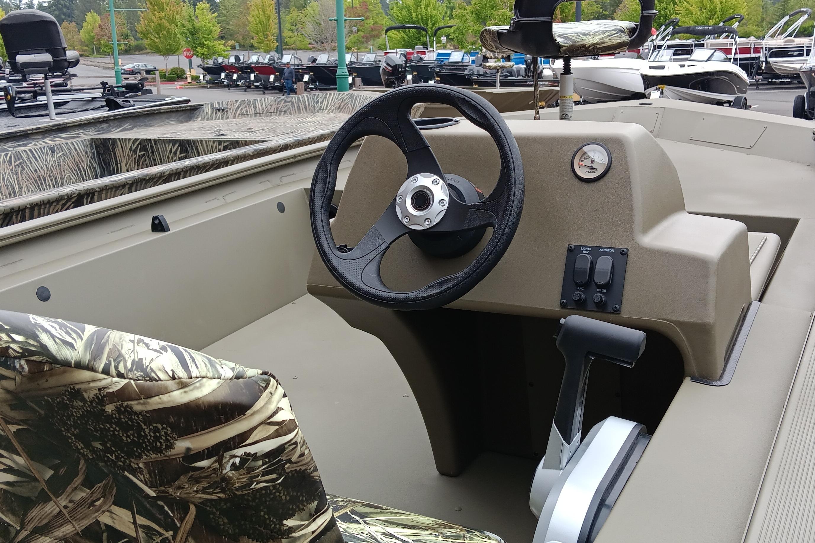 2026 Tracker Grizzly 1754 SC boat interior with camo seats and steering console.