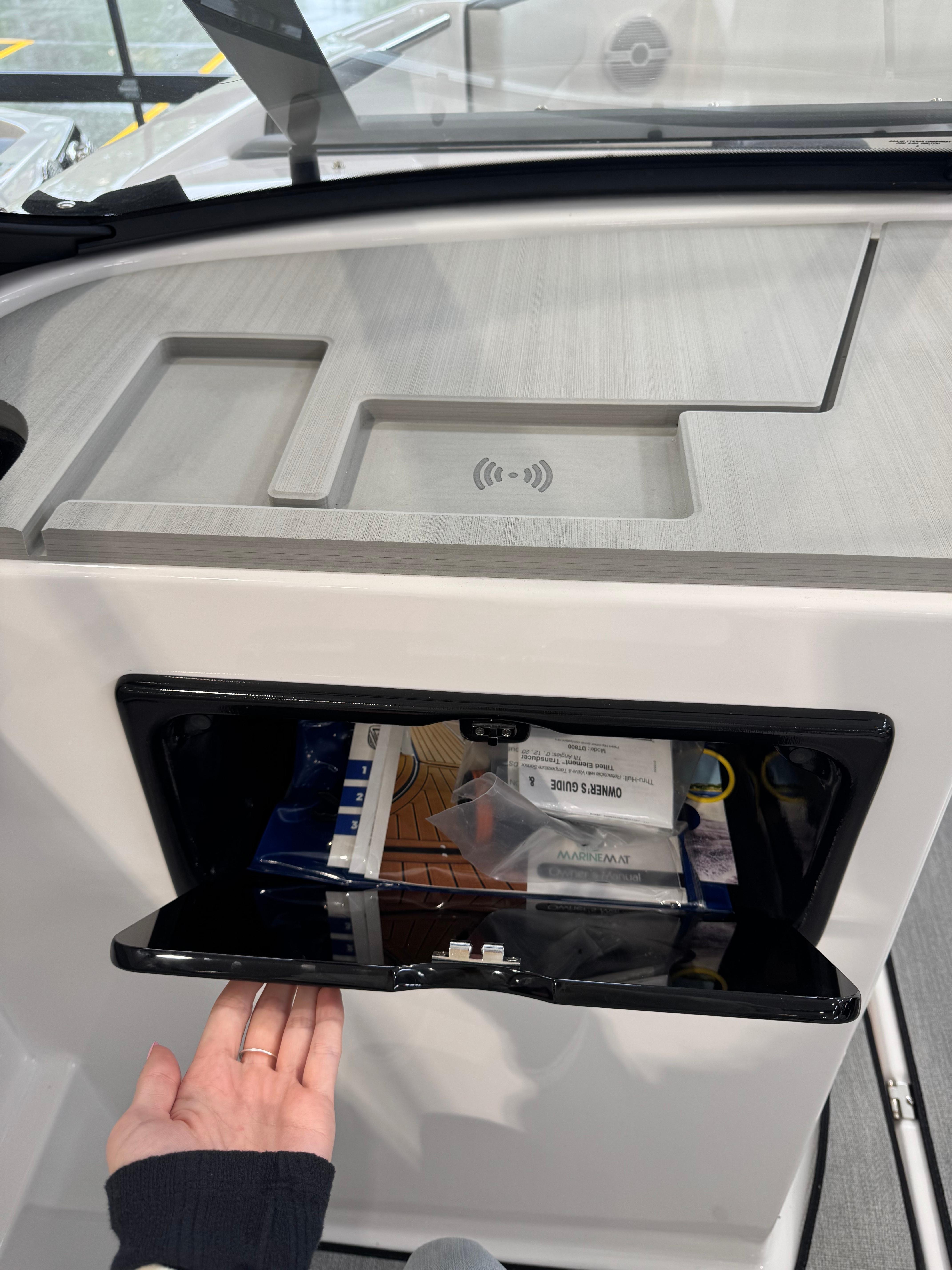 2025 Yamaha Boats SX220 dashboard with storage compartment and wireless charging pad.