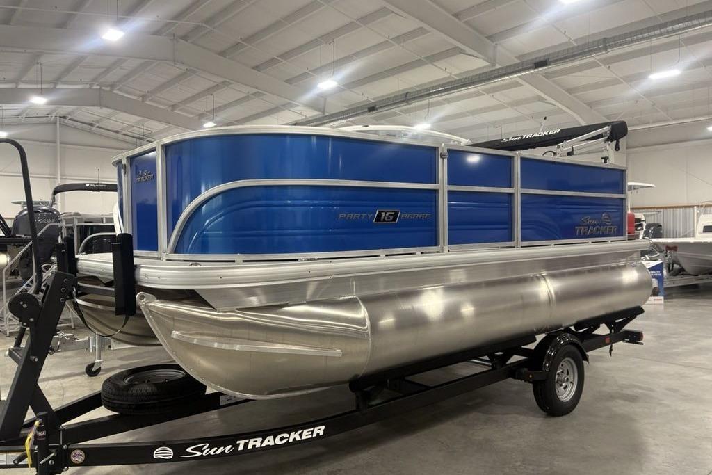 2026 Sun Tracker Party Barge 16 DLX pontoon boat in showroom, blue and silver design.