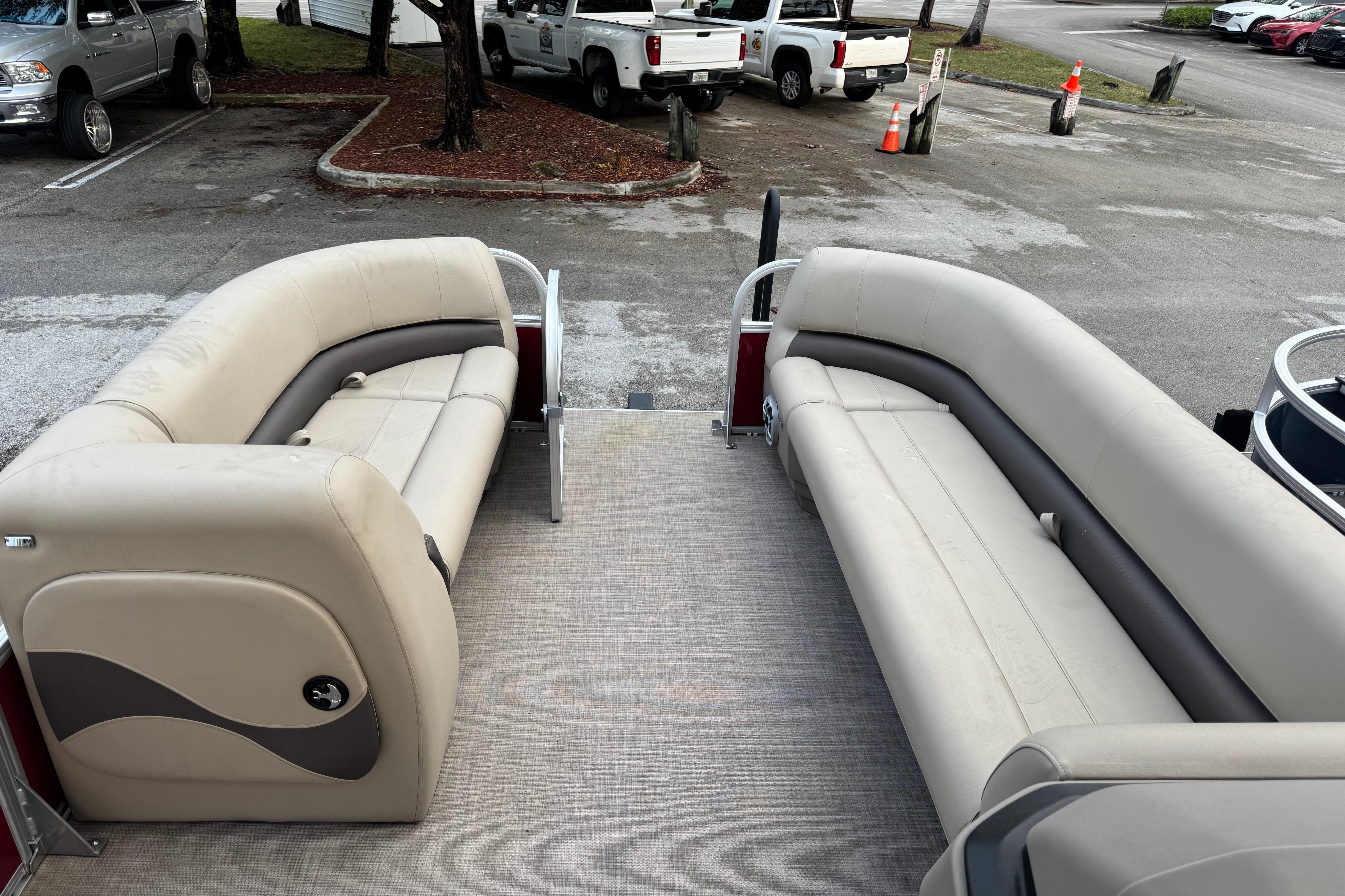 2025 Sun Tracker Party Barge 18 DLX with spacious seating in a parking lot.
