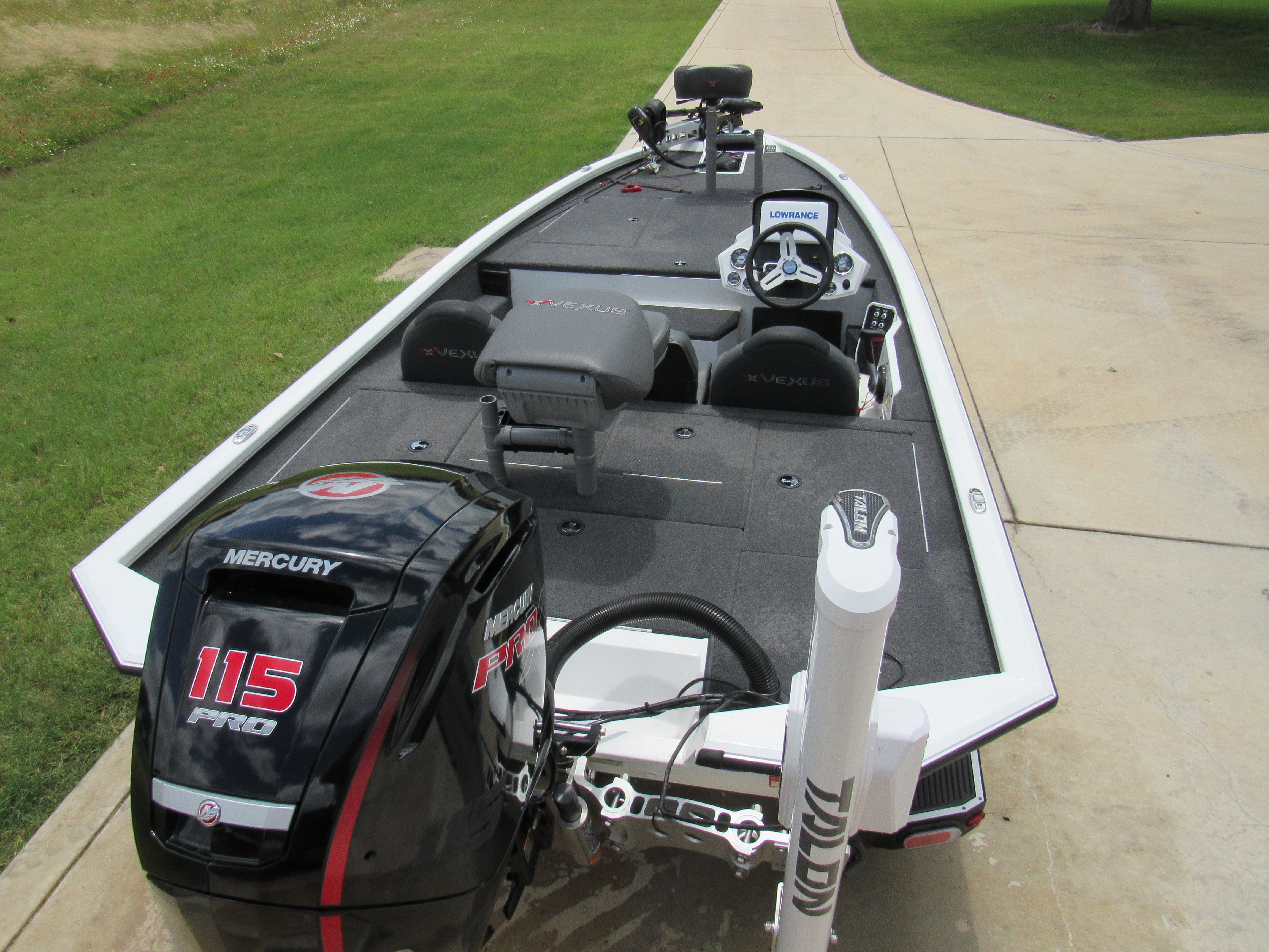 A 2019 Vexus AVX 1880 boat with a Mercury 115 Pro engine on a paved path.