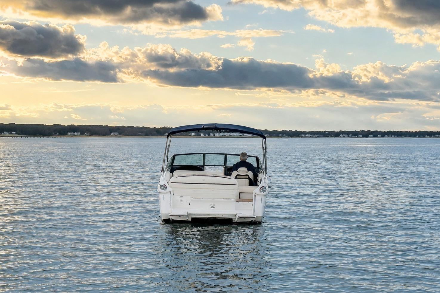 2019 Cobalt R3 boat on calm water at sunset, under a cloudy sky.