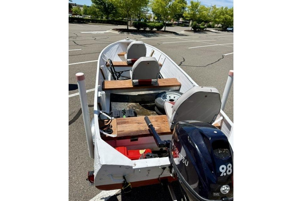 1958 Jon Boat Aluminum model with Tohatsu motor in a parking lot.
