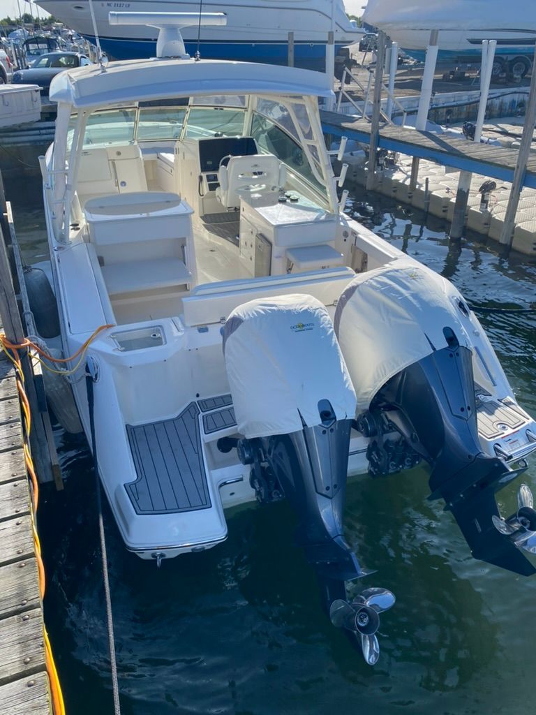 2023 Cobia 330 boat with twin outboard engines docked.