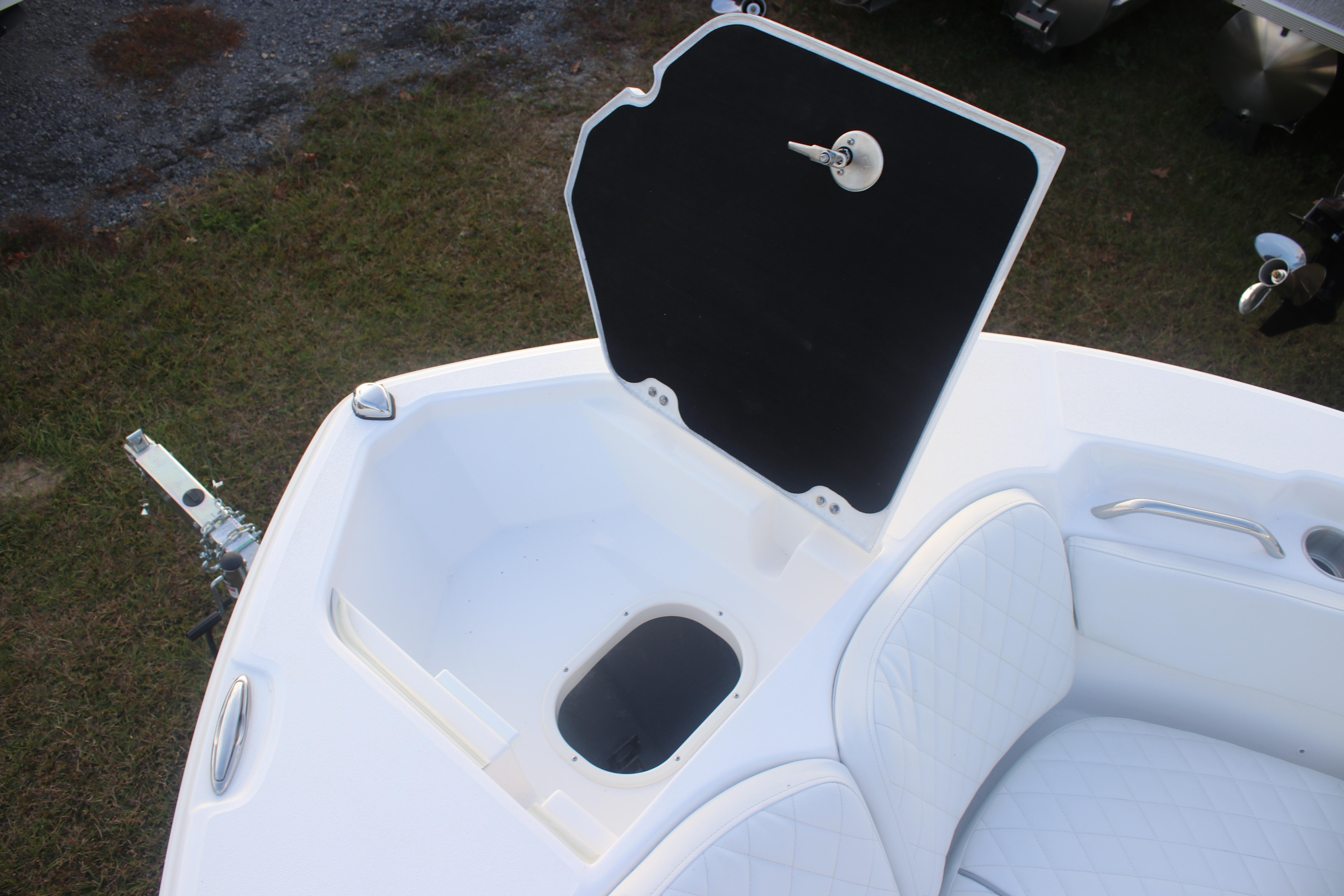 Open storage compartment on 2026 Sea Fox 228 Commander boat, featuring white cushioned seating.