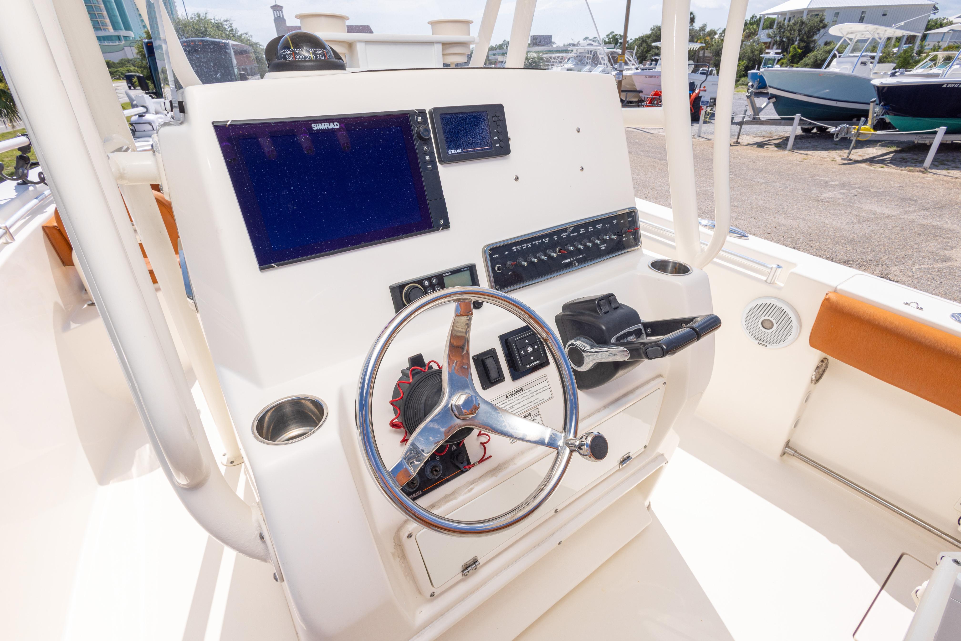 2017 Cobia 261 Center Console boat dashboard with steering wheel and navigation screens.