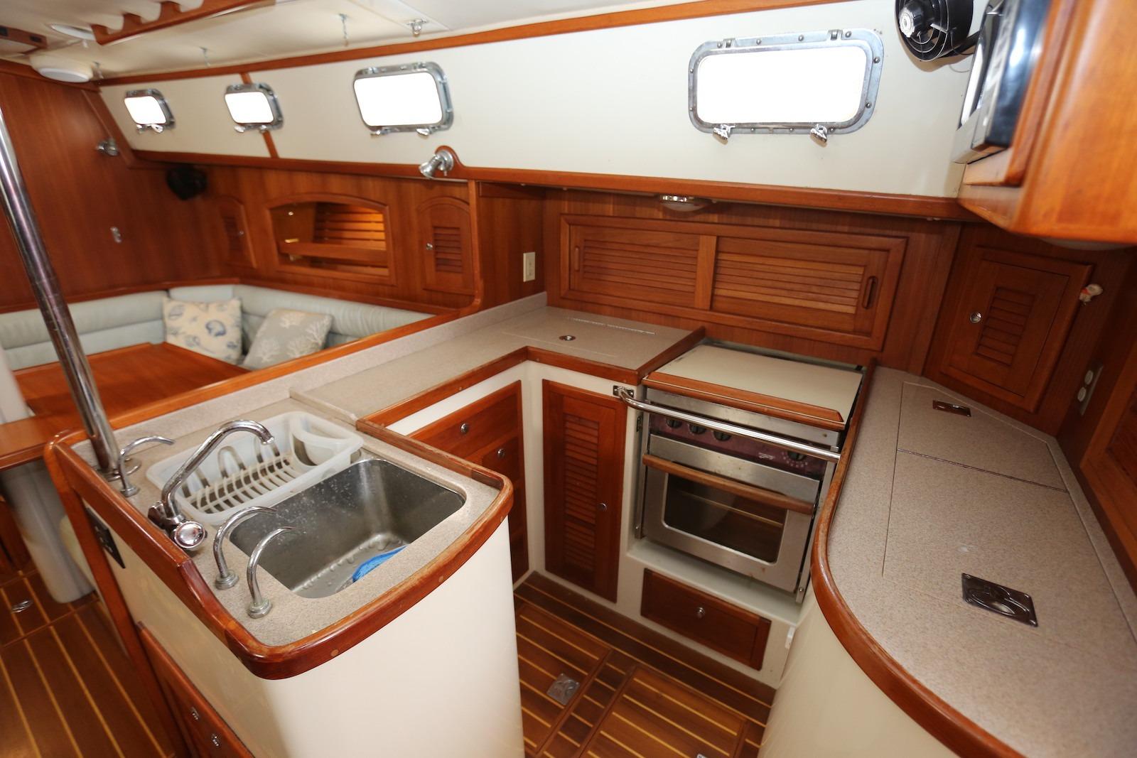 Interior of 2004 Pacific Seacraft 40 sailboat, featuring a well-equipped kitchen and cozy seating area.