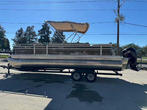 2025 Sun Tracker 24 Sportfish XP3 pontoon boat on trailer, parked outdoors.